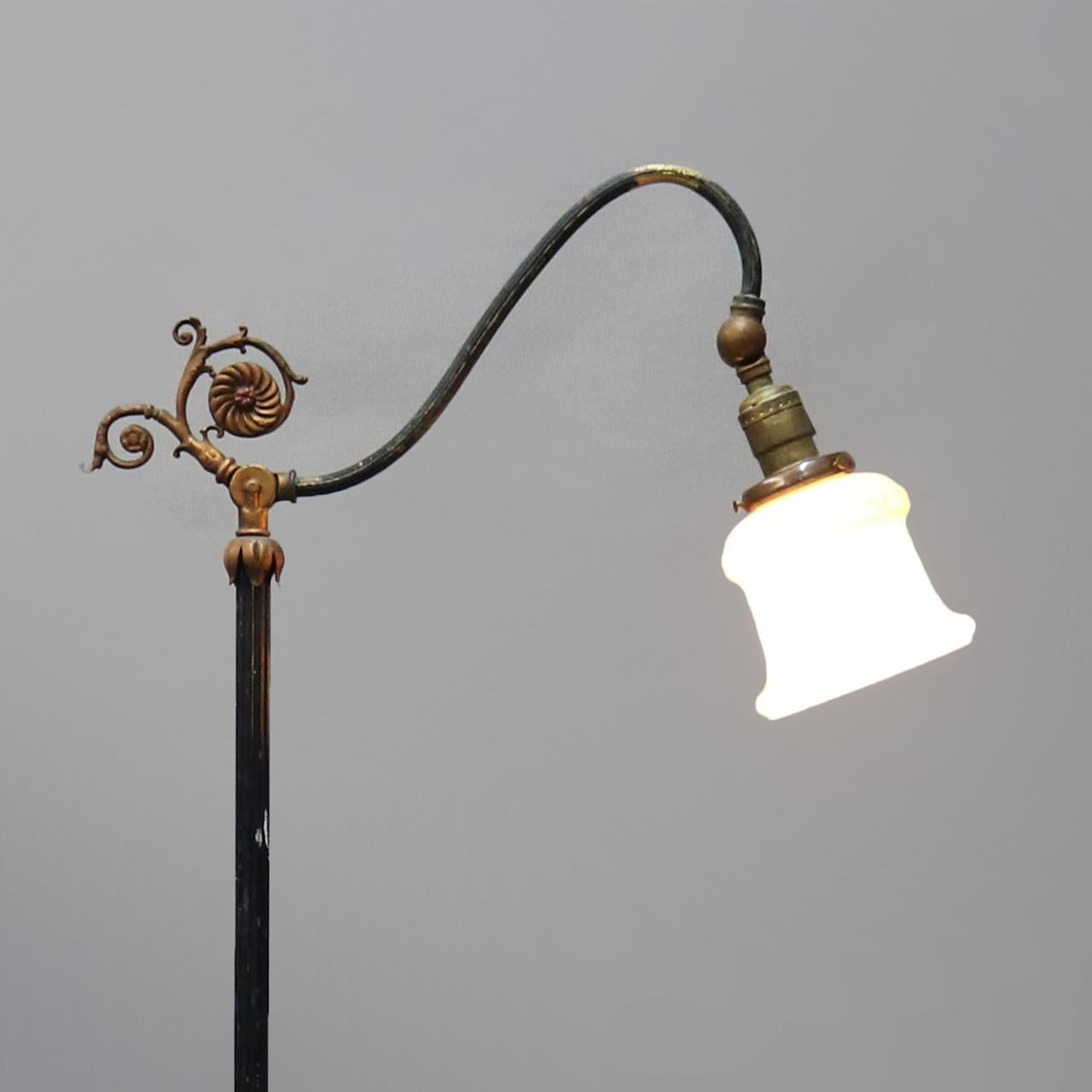 An antique English bridge floor lamp offers scroll form goose neck terminating in adjustable light and raised on cast foliate decorated column base, professionally rewired, circa 1920

Measures: 58.5