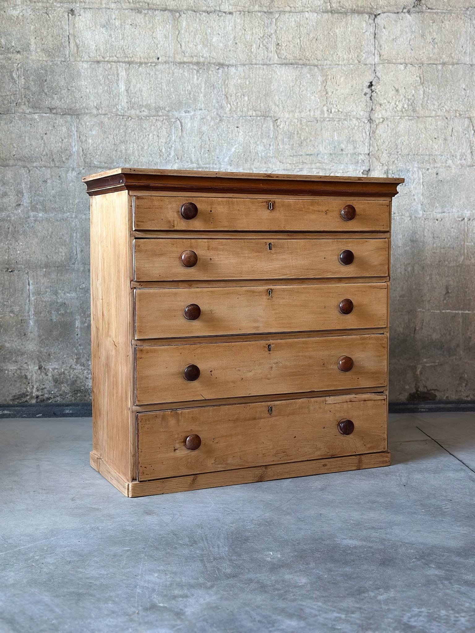 Une commode spectaculaire. Pin frotté anglais de la fin du 19e siècle. Boutons larges et plats patinés avec détails en laiton en forme de trou de serrure. Une pièce antique parfaite avec beaucoup de caractère. 