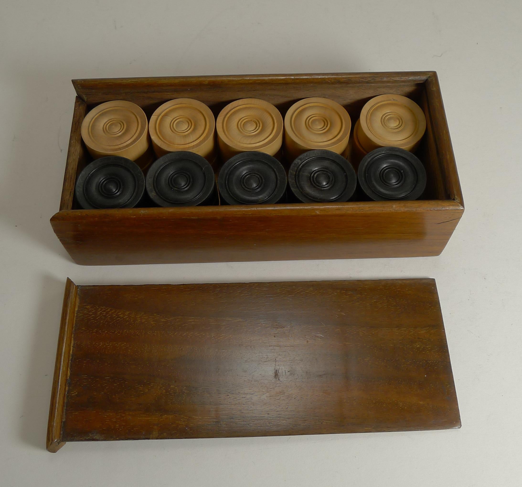 A fabulous boxed set of late Victorian or early Edwardian games counters, perfect for Draughts or Backgammon.

The set is complete and undamaged, with 15 each of turned ebony and boxwood counters; all contained in a polished wooden storage box,