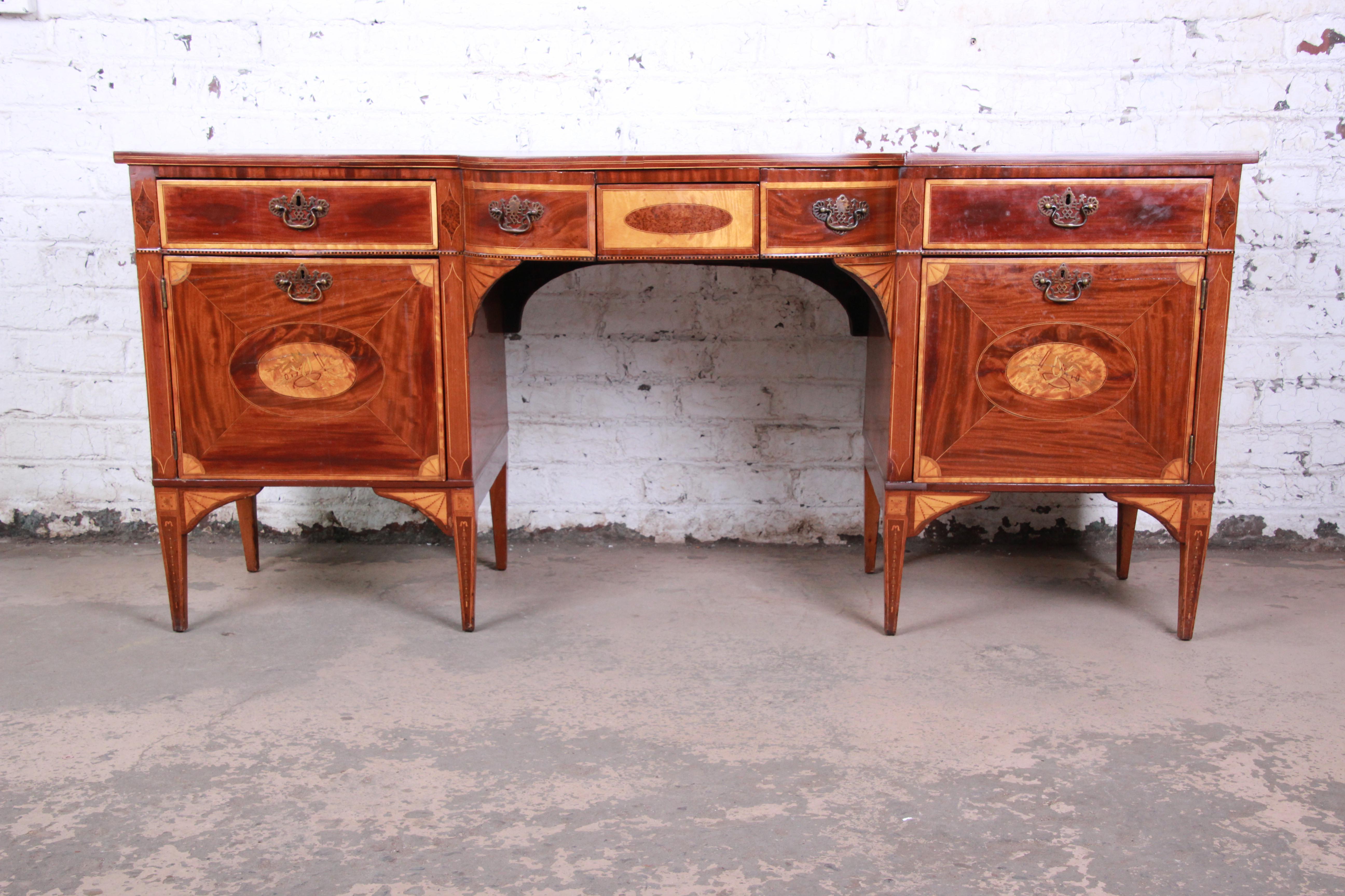 A truly rare and exceptional English Sheraton bow-fronted mahogany sideboard, circa 1820. The sideboard features stunning flame mahogany and birch wood grain, inlaid with chequer pattern bands and stringing and with fan pattern medallions to the
