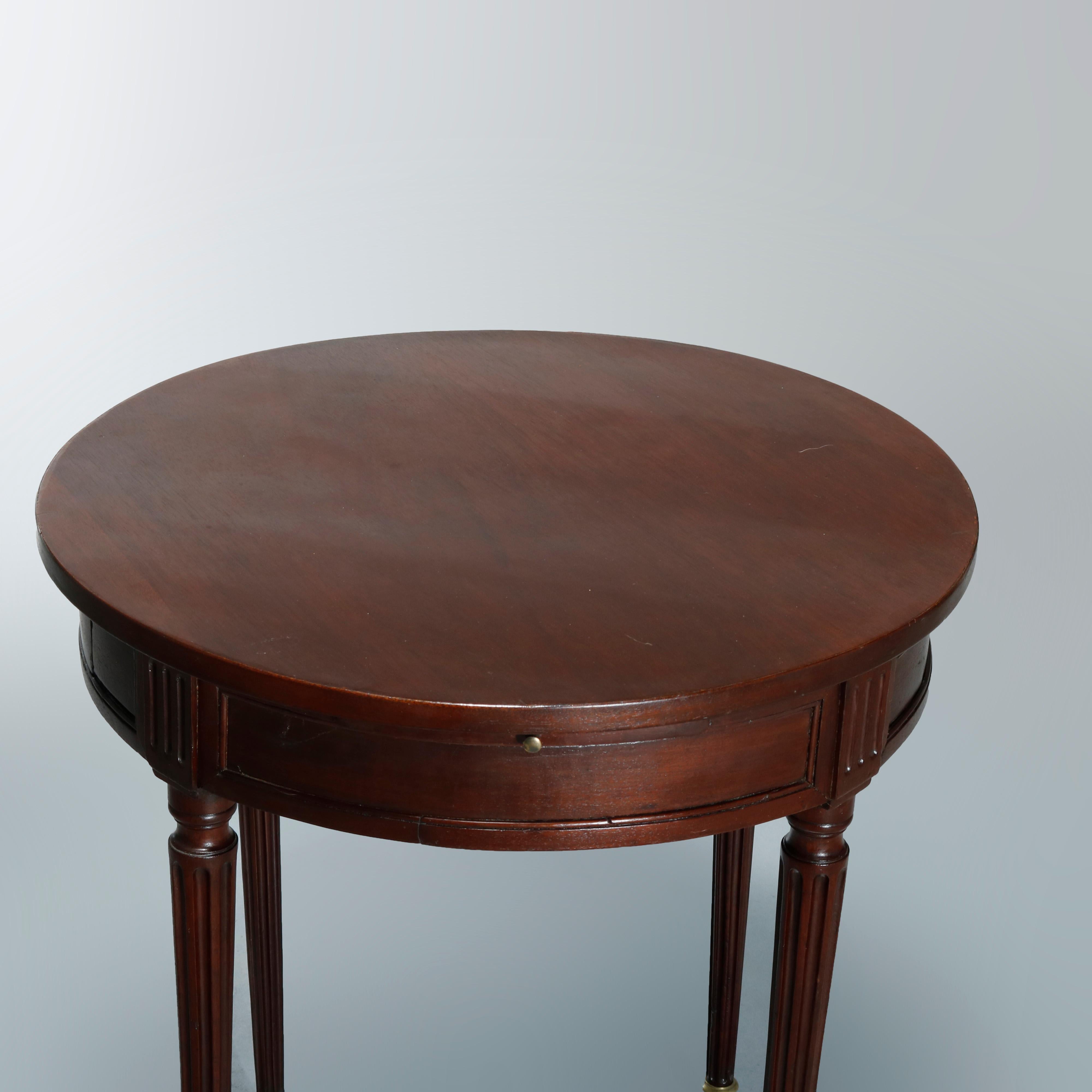 An antique English Sheraton game or side table offers mahogany construction in round form and having single drawer, raised on tapered and reeded legs terminating in casters, c1830

Measures: 28.75