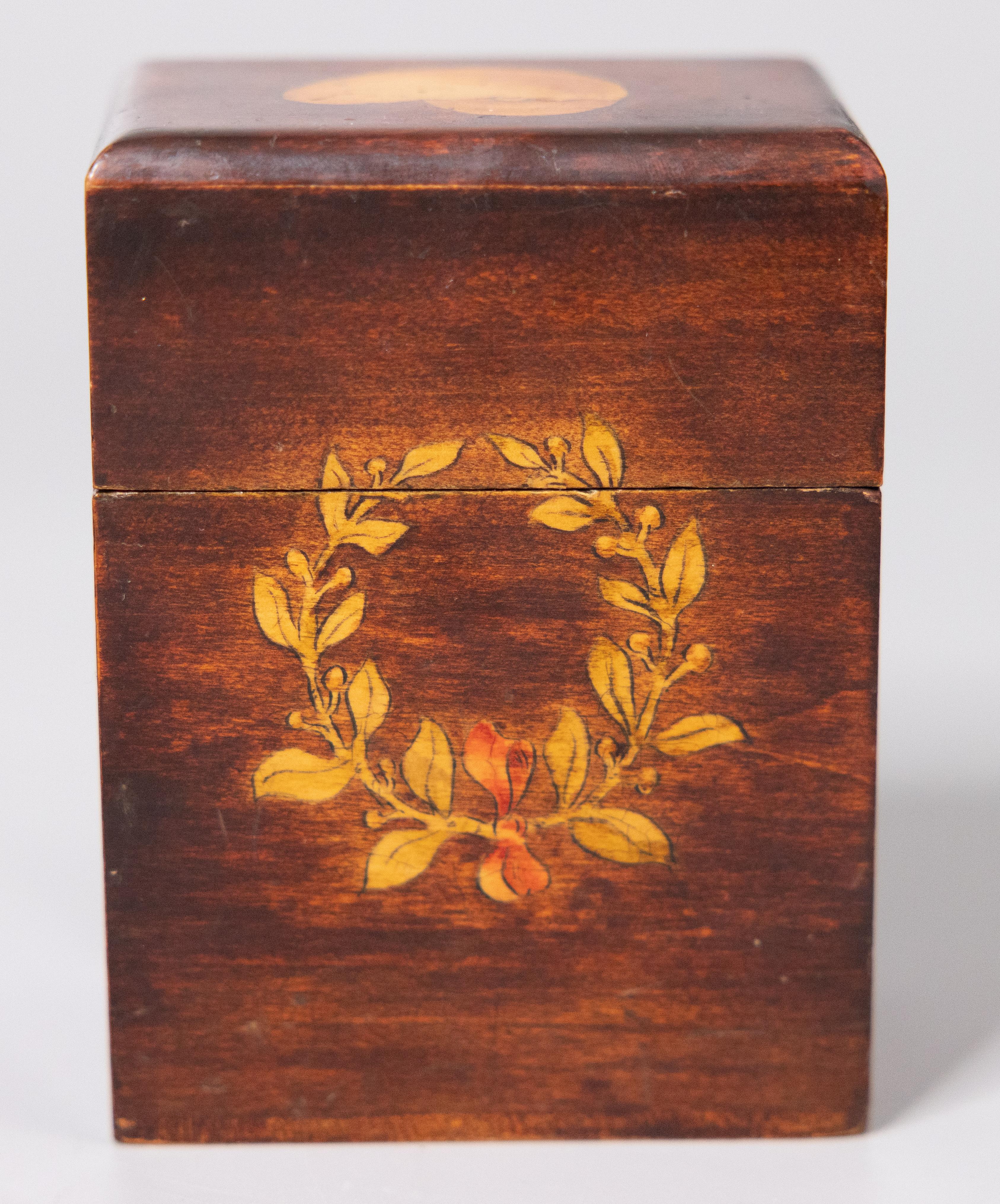 A fine antique English Sheraton style mahogany playing cards box, circa 1910. This lovely box has a hand painted wreath on one side and musical lyre design on the other side with a shell decoration on the lid. A set of vintage playing cards is