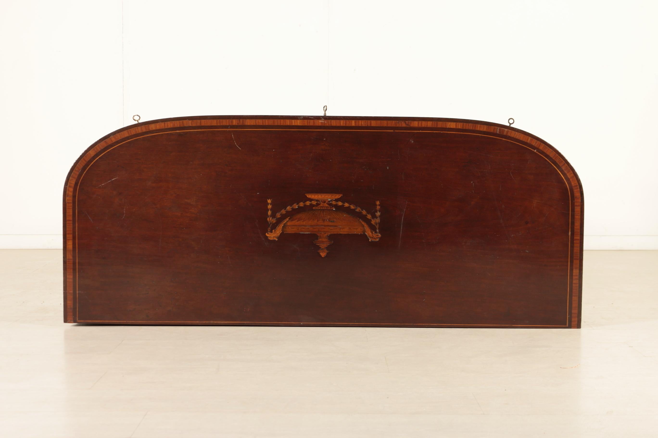 Sideboard veneered in mahogany, has two doors and two drawers with neoclassical inlays in various woods, top has a thread and inlay with motifs taken from the Adams models. Truncated pyramidal legs. Late 1800s, England.

Packaging with bubble wrap