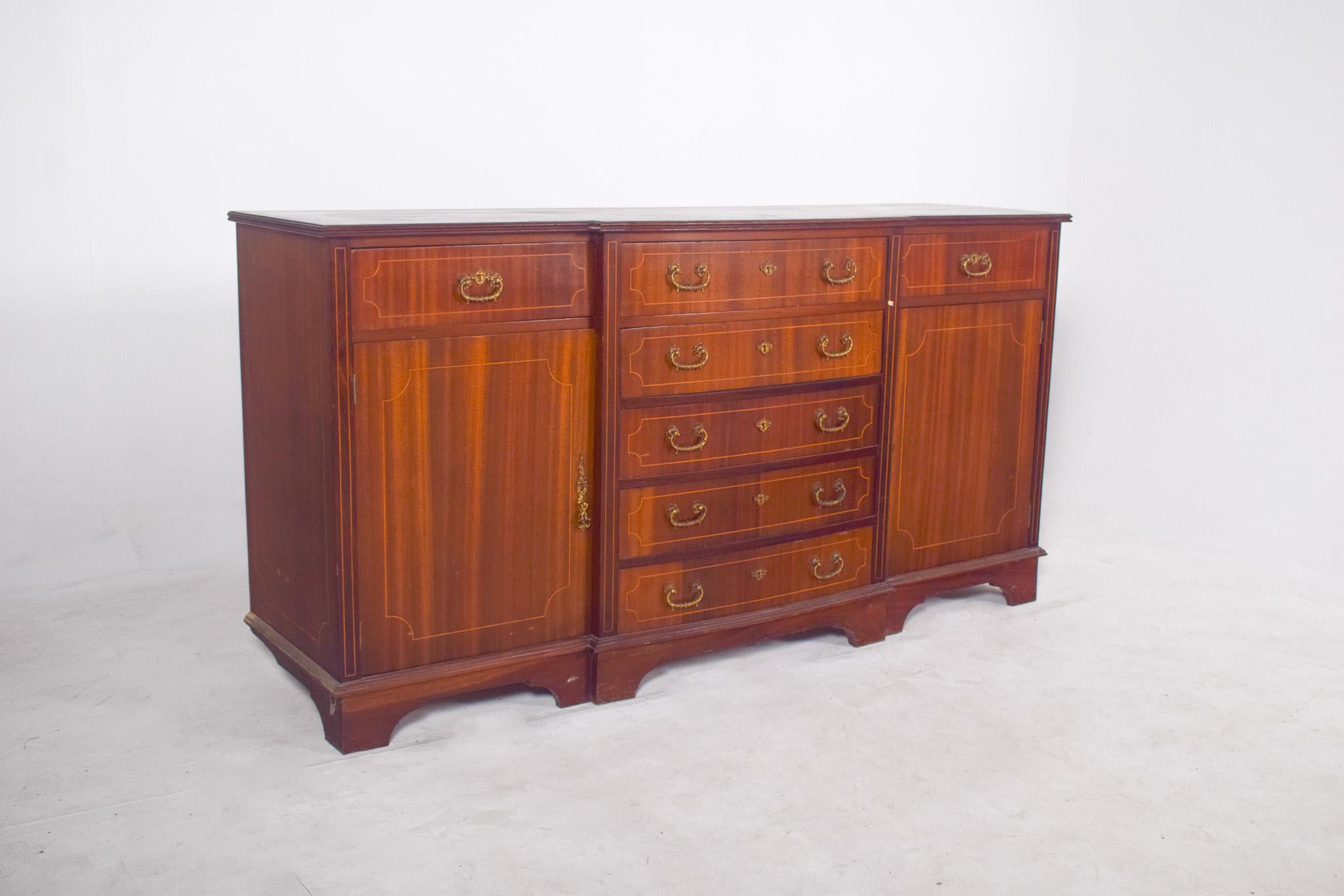 English sideboard with marquetry work. Characterized by a symmetrical and well-proportioned structure with a satin mahogany finish, the sideboard has three distinct zones, two side doors and a central section with five drawers, all with gold brass