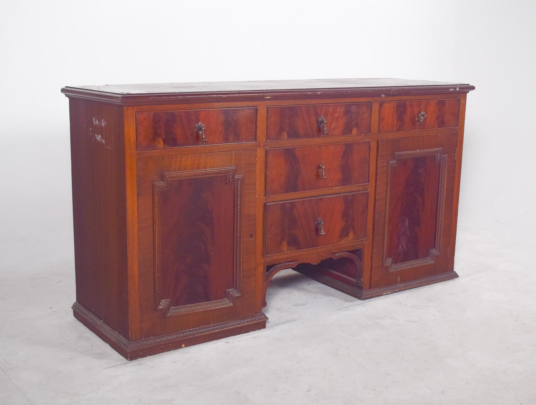 Sideboard with two doors and five drawers. With its sober and elegant lines, probably from the late 19th or early 20th century, the piece has a symmetrical design with three top drawers, three central drawers on a vertical column and two side doors