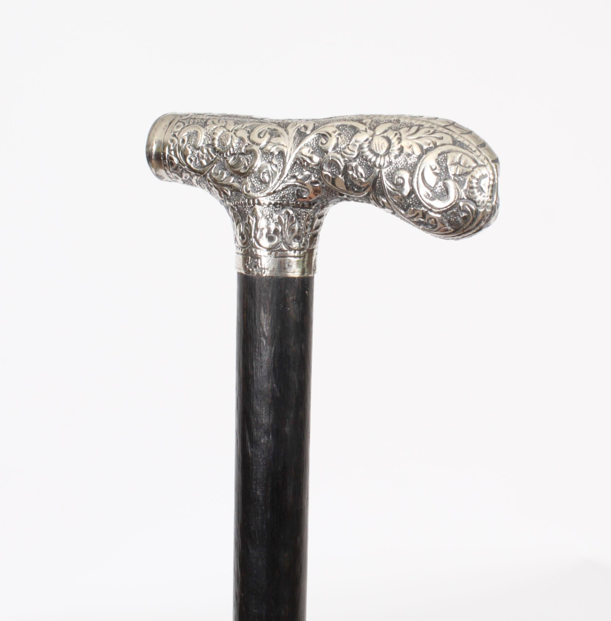 This is a beautiful antique sterling silver pommel walking stick circa 1880 in date

The striking stick features an ornate silver crutch handle having a profusely embossed floral design, on a gentle tapering ebonized shaft, it has its original brass