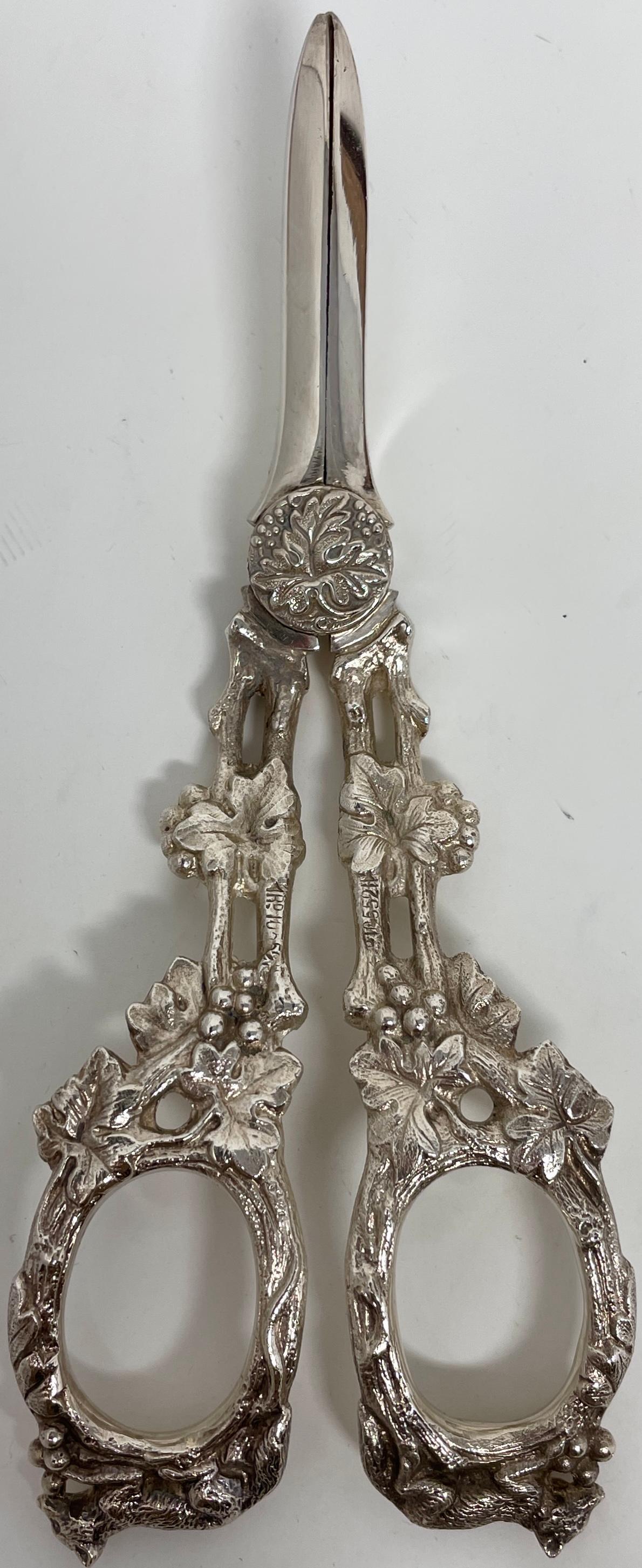 Antiguas tijeras inglesas de plata para uvas y cucharas para bayas en su estuche original, hacia 1880.