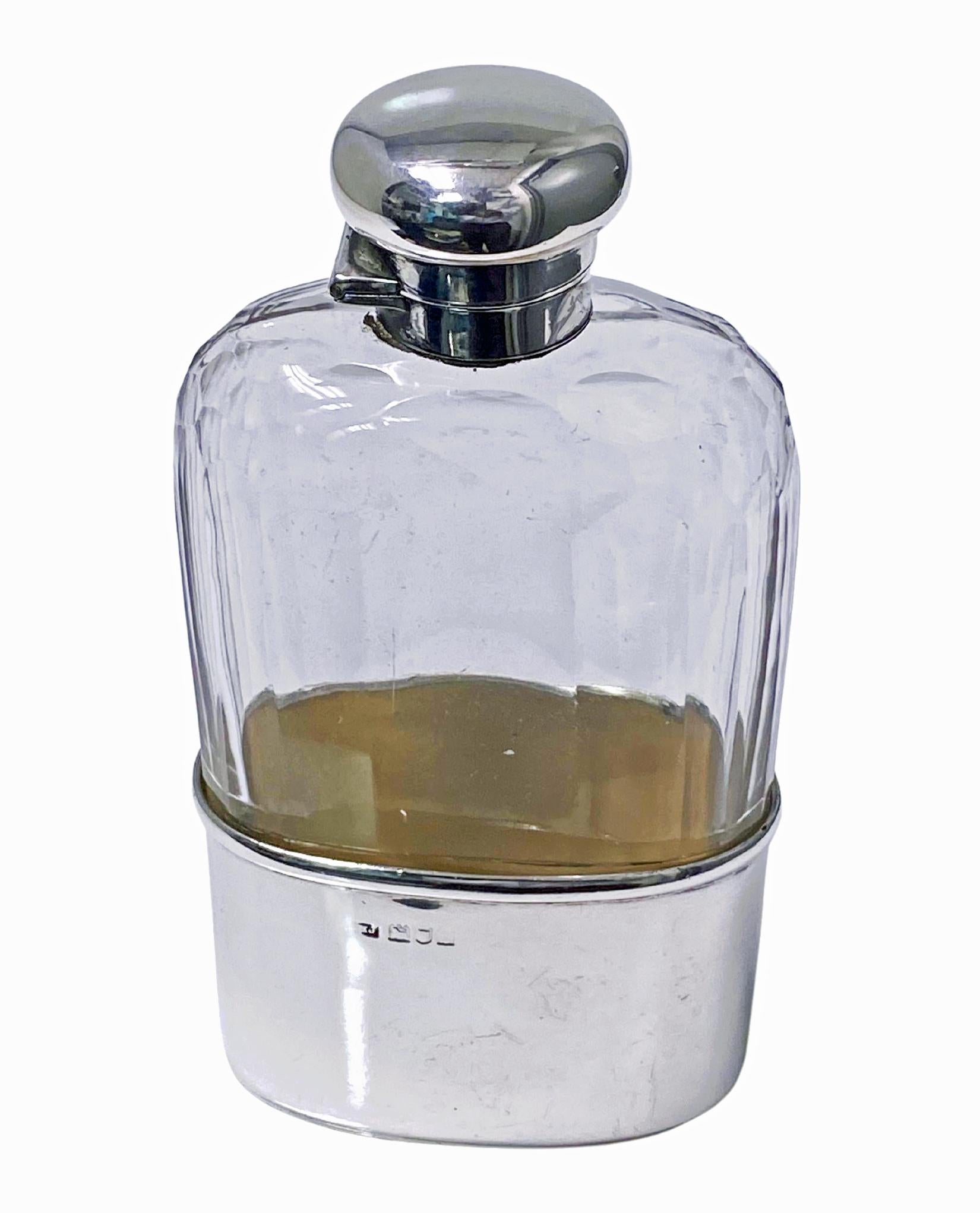 Antique English Silver hip flask, London 1906, George  Henry James. The flask with lower silver detachable cup, gilded interior, upper faceted panel glass, silver bayonet top.  Measures: 5.50 x 3.0 x 1.25 inches. Good condition, no leaks.