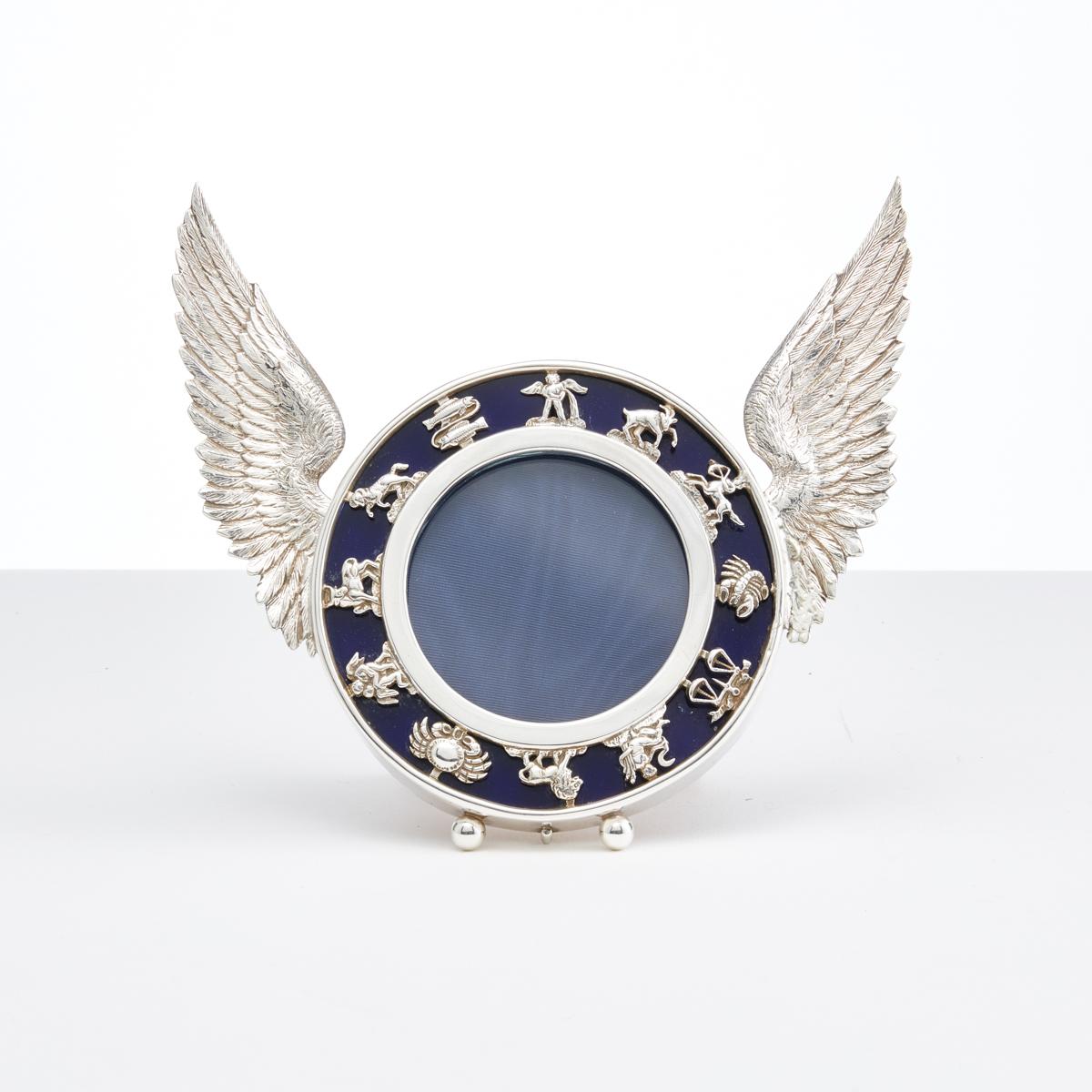 Antique English Silver Photo Frame with Signs of the Zodiac by W Lockwood & Co, London 1899. 

This cast silver surround and wings are beautiful quality the front has a disc of Bristol Blue glass in the background, with overlay signs of Zodiac.
 


