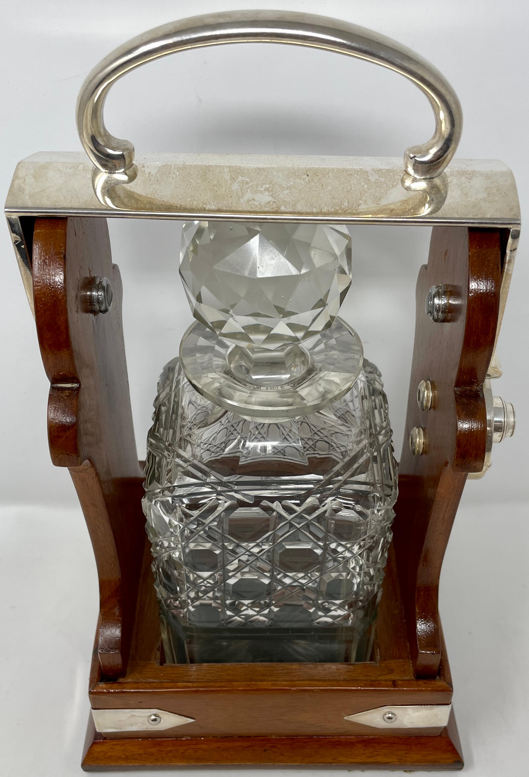 Antique English Victorian golden oak and cut crystal single bottle tantalus with Sheffield silver-plated mounts, circa 1890.