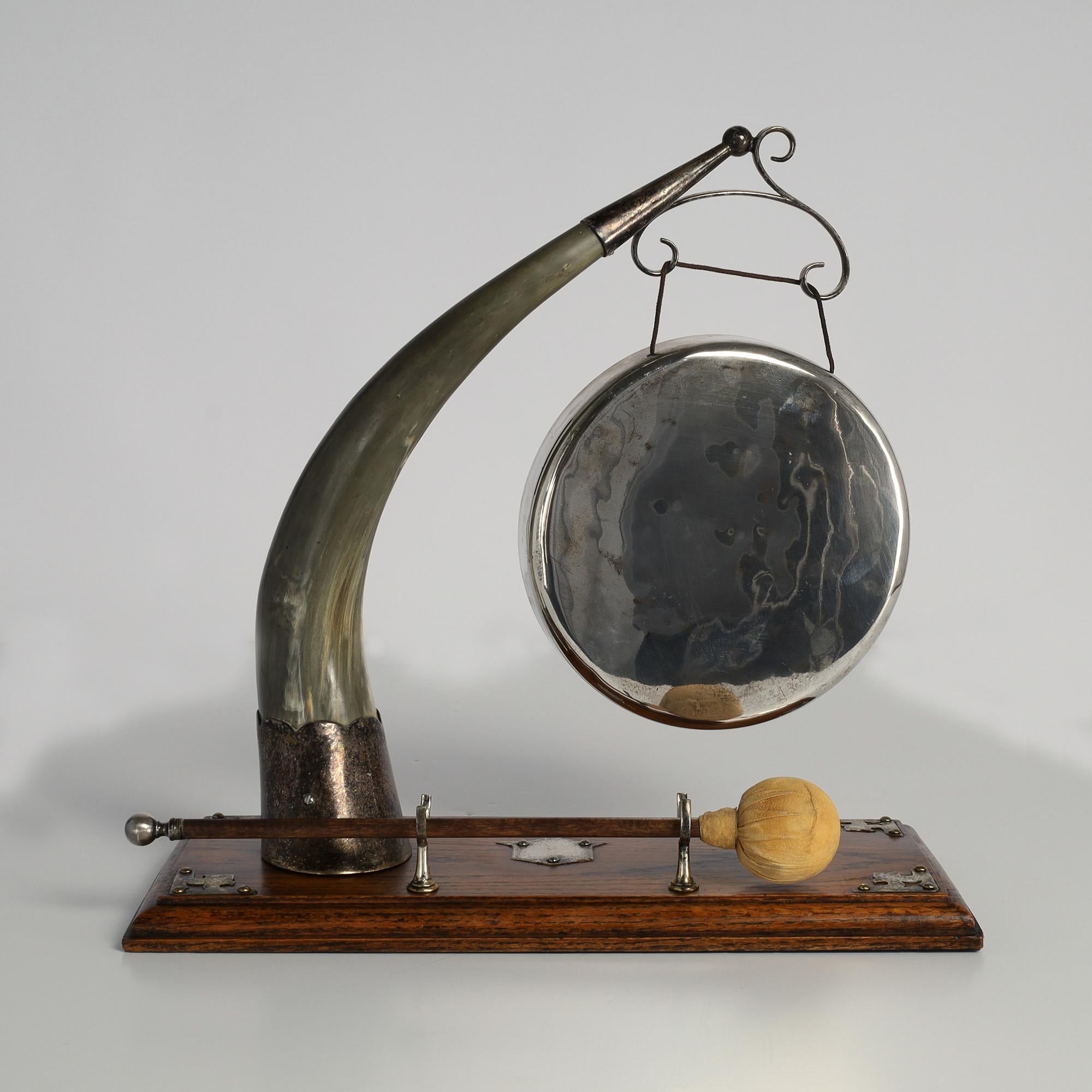 Transporting 19th Century English silver plate gong supported by a steer horn with silver plate cuffs on an oak base with an un-engraved plaque and the original padded mallet. 