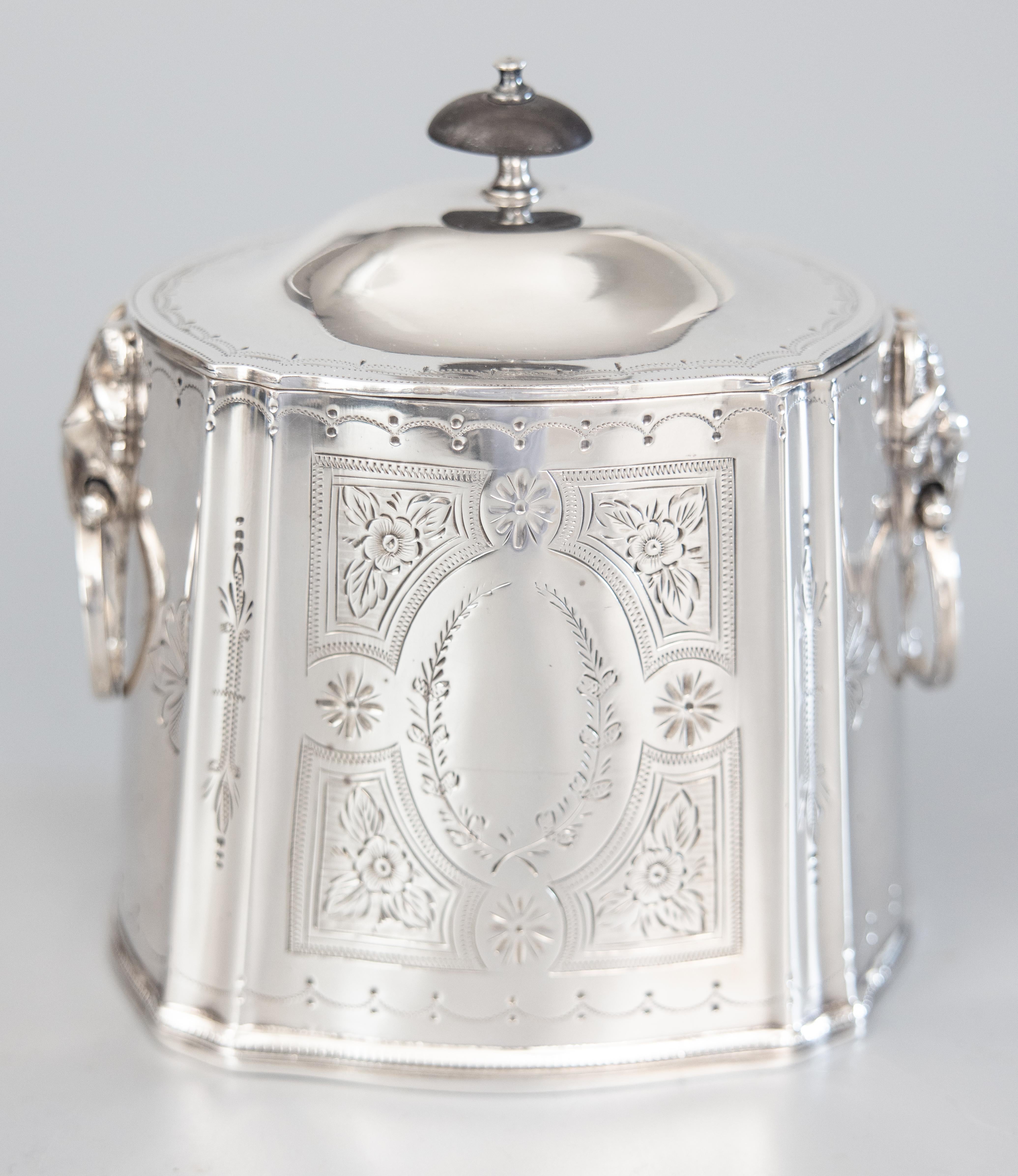 A superb antique English Georgian style silverplate tea caddy or biscuit barrel with hinged lid, circa 1900. No maker's mark. This Fine quality box has a beautiful etched floral design, beaded trim, and ram head ring handles, perfect for display or