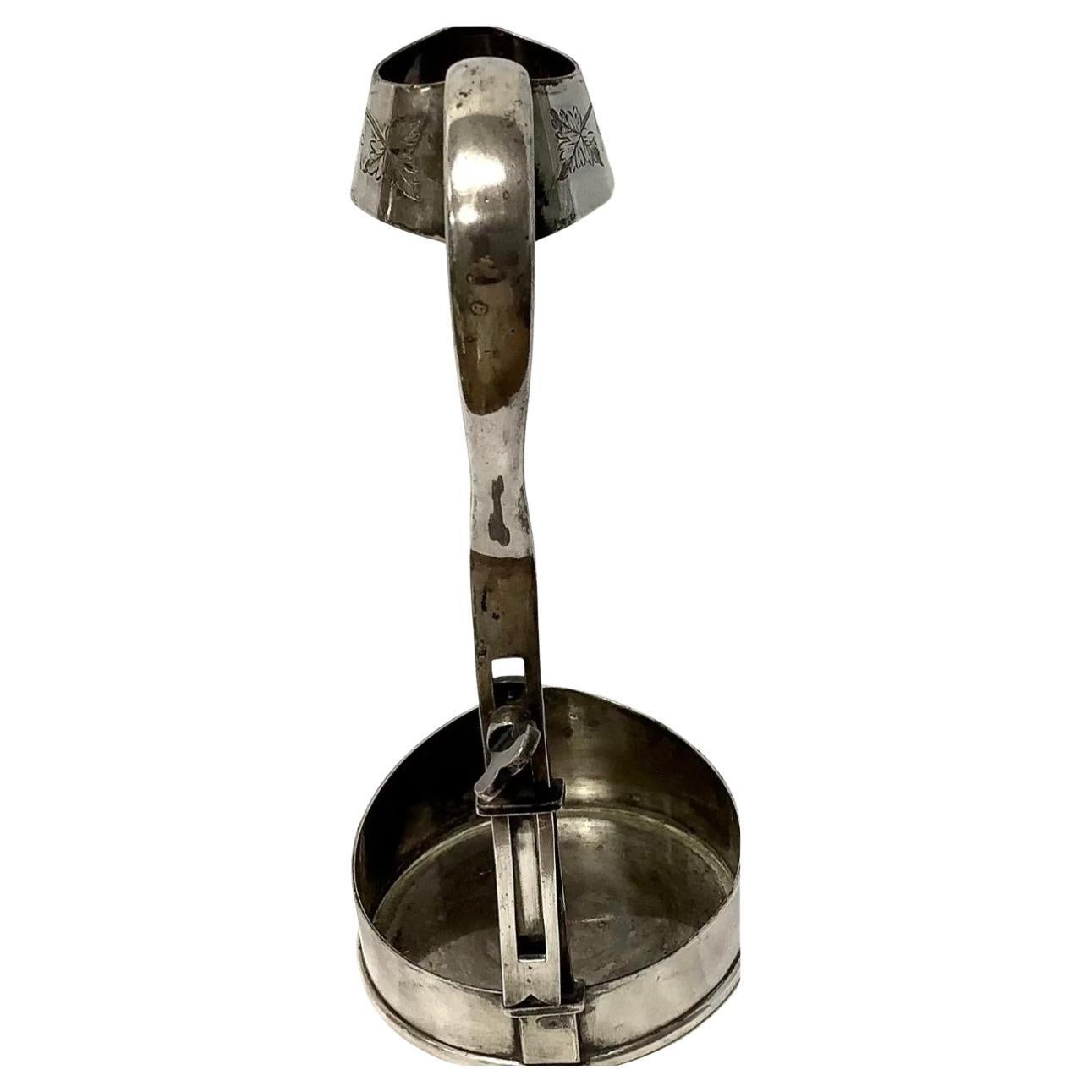Antique Silver Plate English adjustable wine bottle holder. Floral embossing on both top and bottom. The handle is sleek and easy to carry. Very unique and chic item for wine connoisseurs. Adjustable back allows for different height bottles.