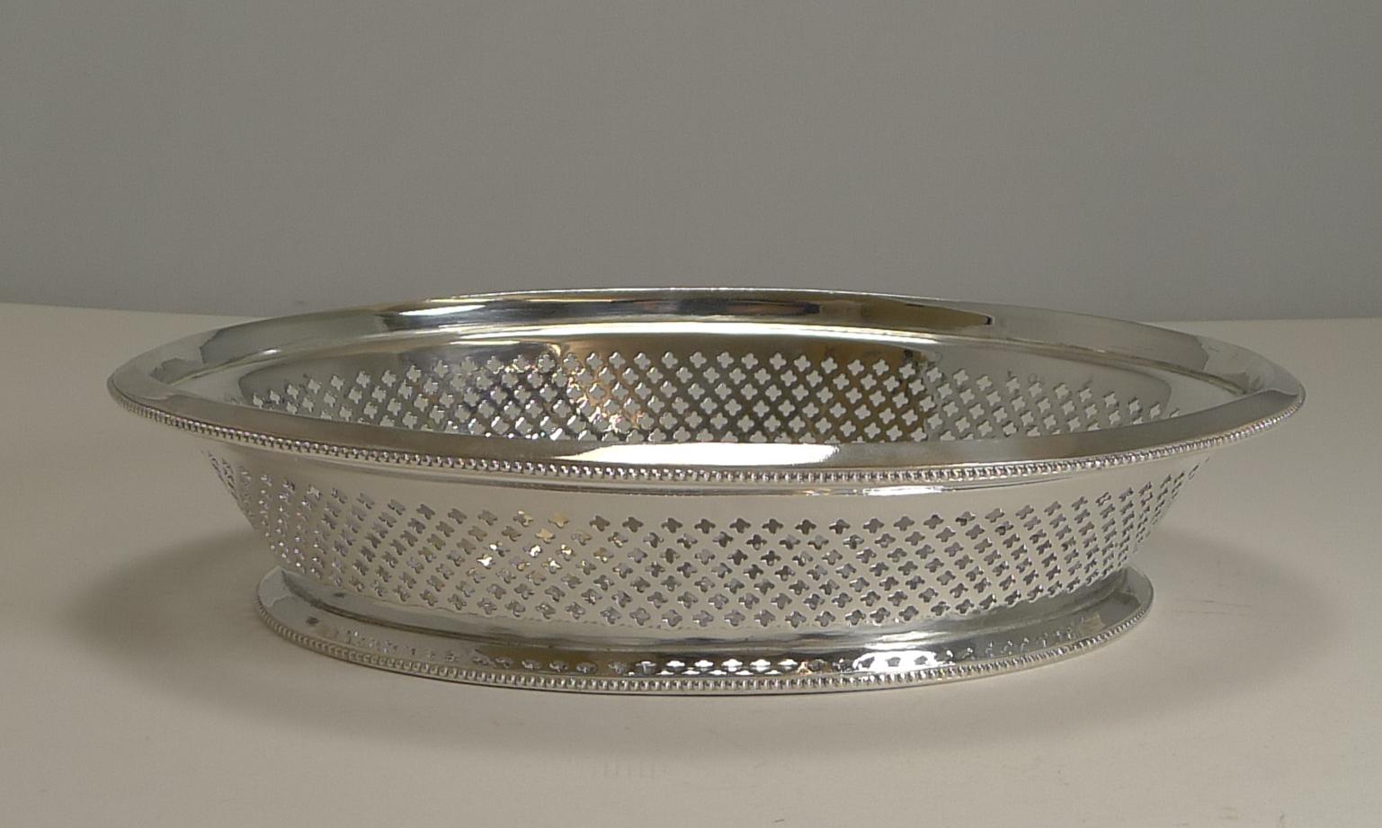 An elegant and very usable bread basket made in EPNS (Electro-Plated Nickel Silver) made by the very famous silversmiths, Atkin Brothers.

The sides of the basket has a series of pierced or reticulated quatrefoil motifs.

The underside is fully