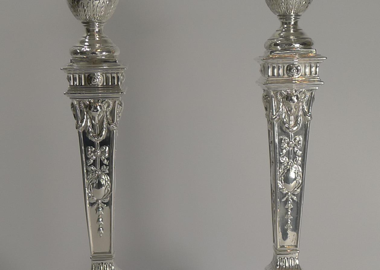 A truly grand pair of late Victorian English candlesticks made from silver plate by Charles Hawksworth & John Eyre
(Hawksworth, Eyre & Co.) of Sheffield.

These Adams style sticks are heavy and substantial with classical ribbon and bow garlands