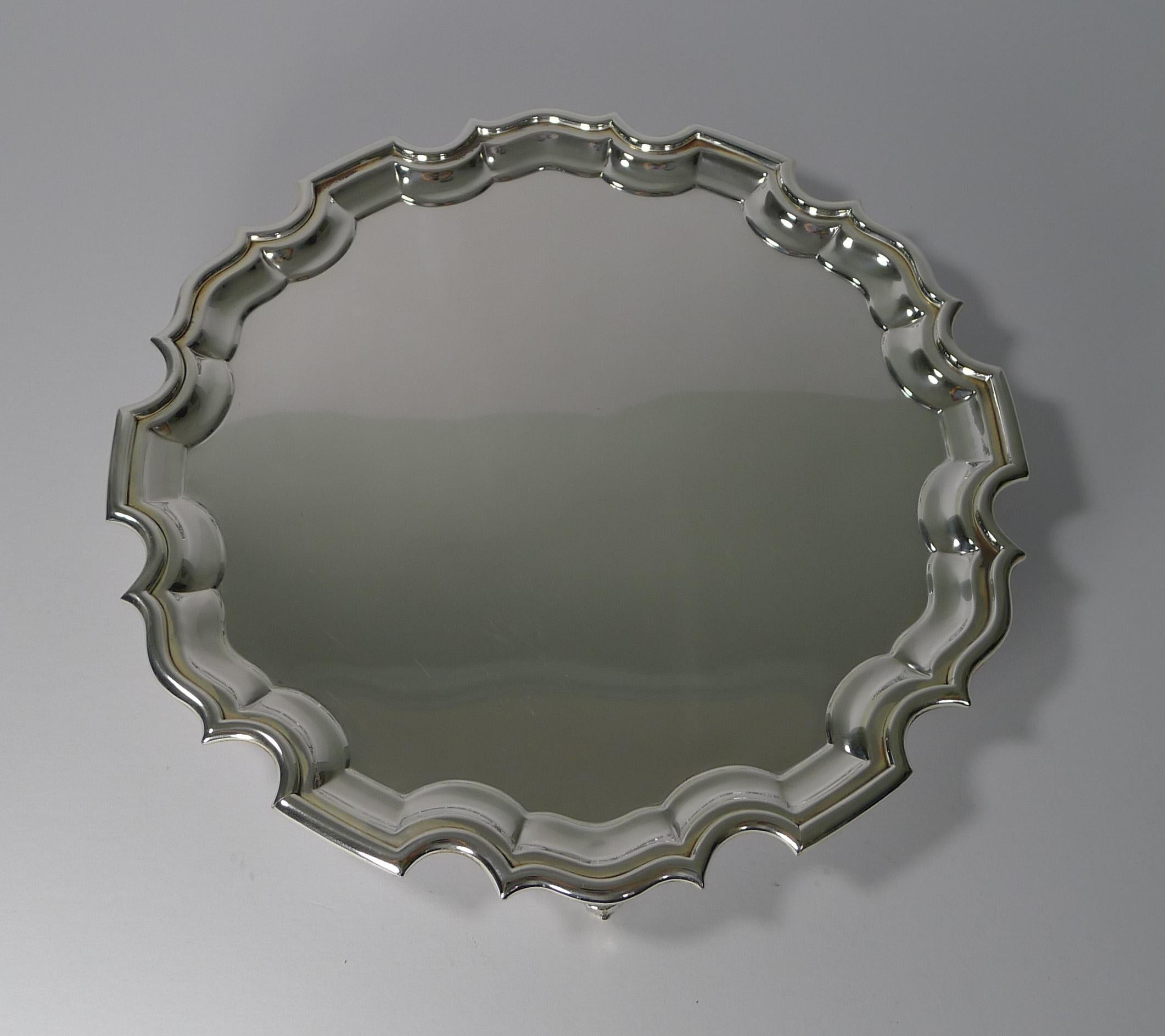 A handsome and very elegant drinks salver or cocktail tray with a Chippendale border and standing on three scroll feet.

The underside is fully marked for the well renowned silversmith, Barker Brothers and EPNS (Electro-Plated Nickel