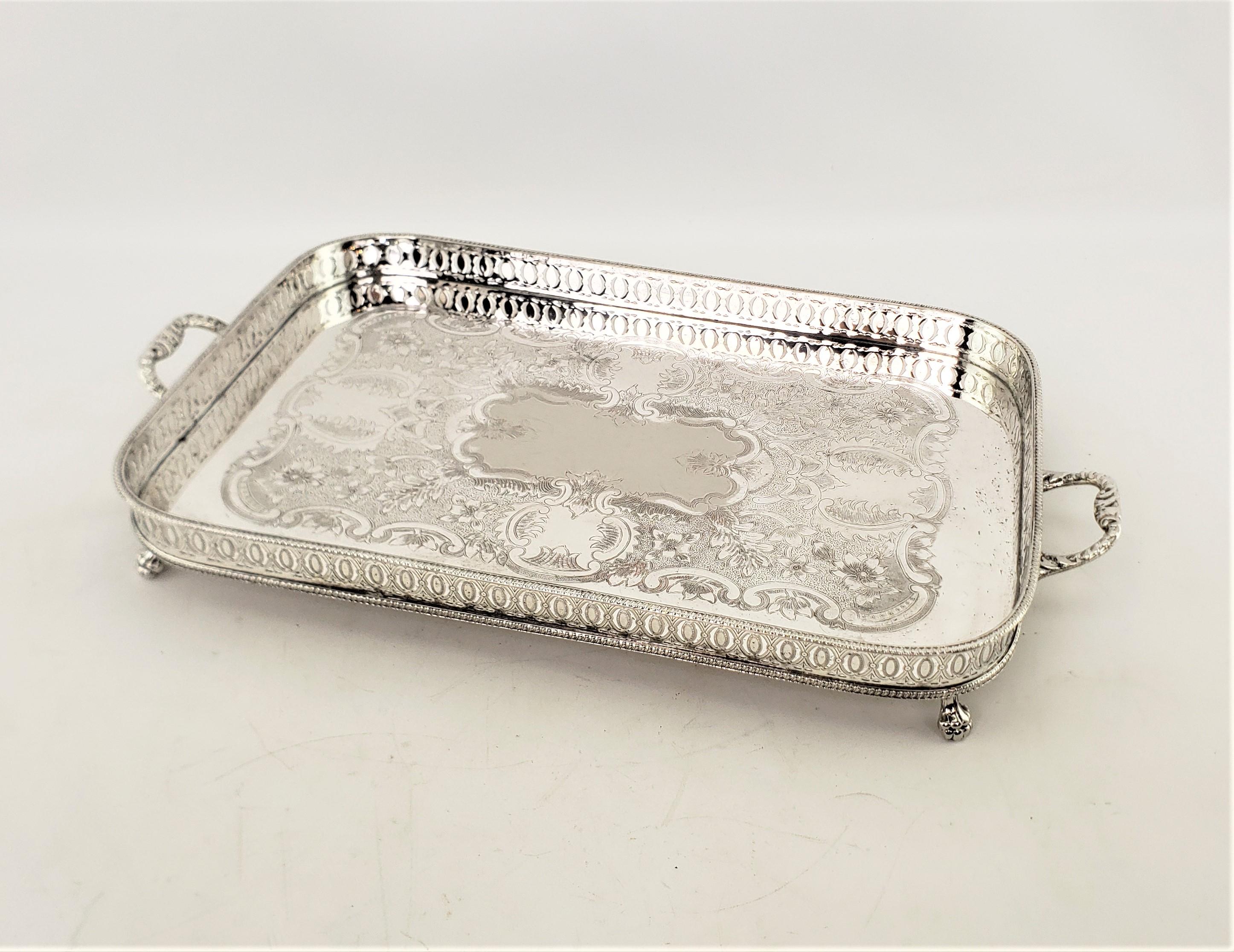 This antique serving tray was made by an unkwown maker and presumed to have originated from England and date to approximately 1920 and done in a period Art Deco style. This rectangular shaped tray is done in silver plate and features a pierced