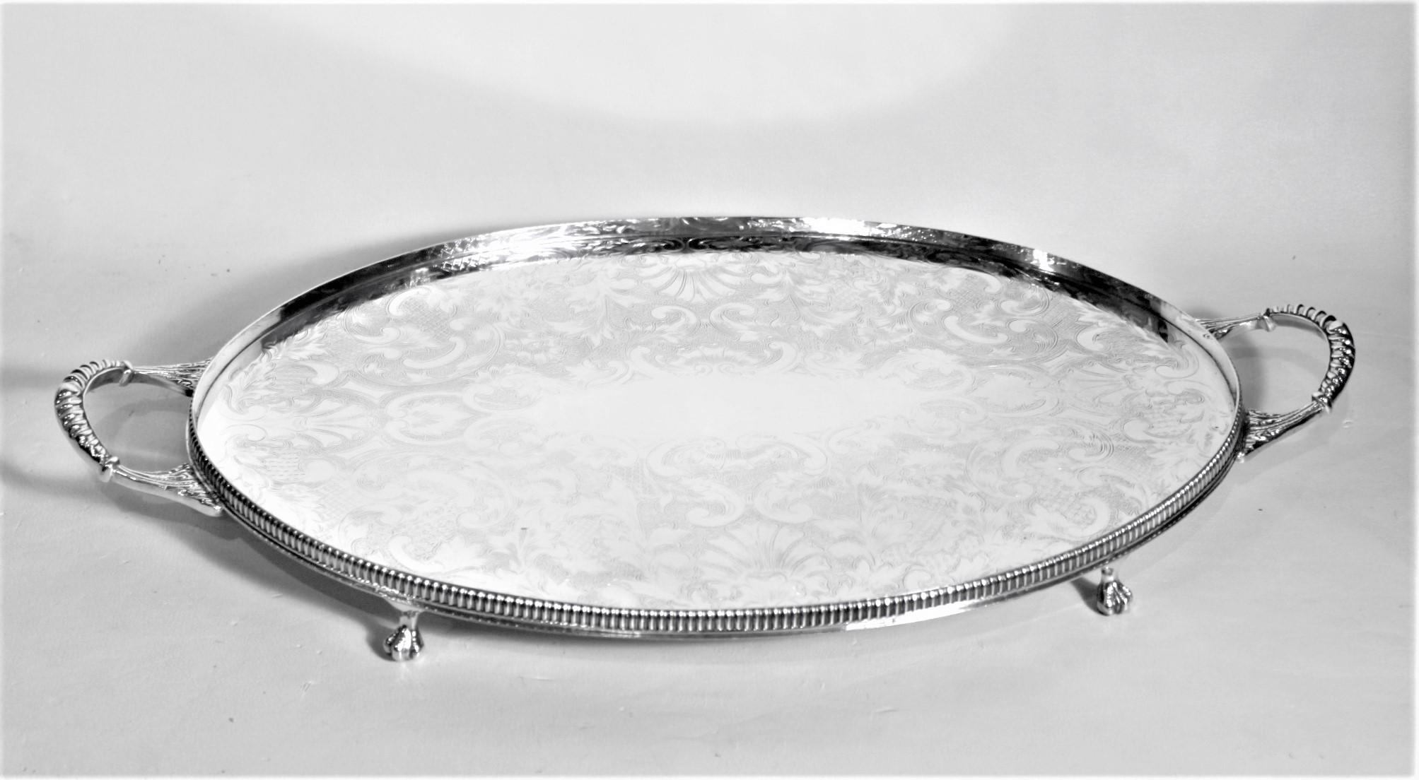 This Sheffield Reproduction silver plated gallery tray was made in Sheffield England in approximately 1920 in a Victorian style. This oval tray has a low gallery and applied handles with talon feet. The top surface of the tray is ornately engraved