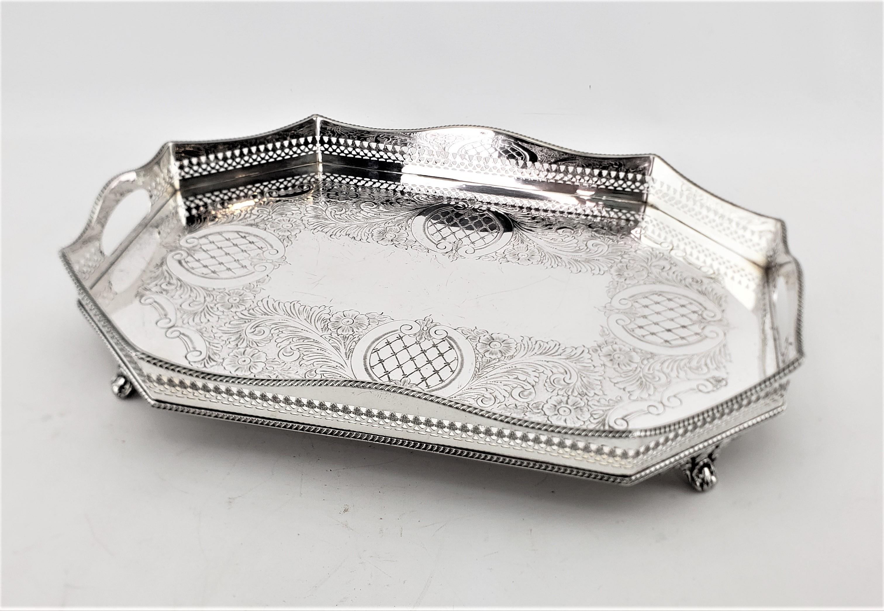 This antique silver plated gallery serving tray was made by the Legacy Plate Co. of England in approximately 1900 in a period Edwardian style. This octagonal silver plated tray is nicely engraved with four cross hatched medallions, accented by