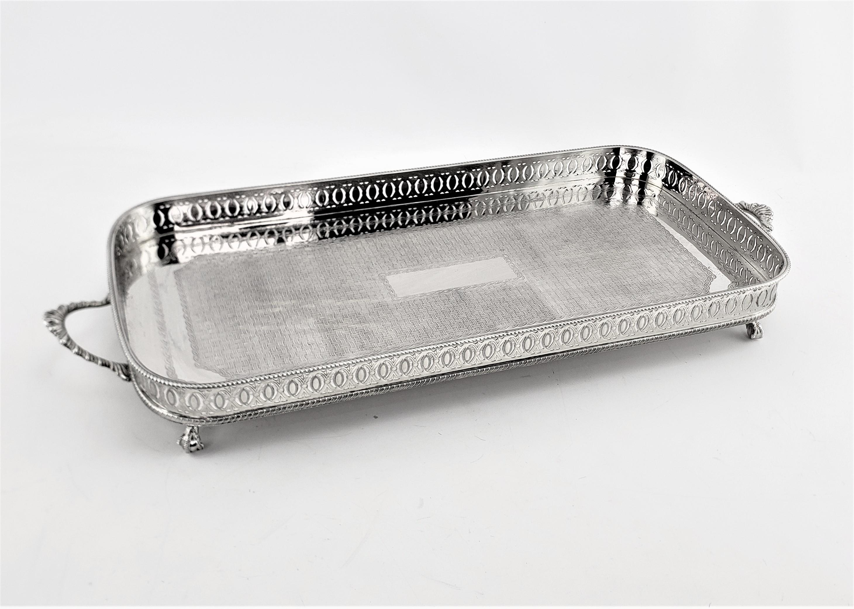 This rectangular silver plated gallery serving tray shows no maker's mark, but originated from England and dating to approximately 1920 and done in an Edwardian style. The tray has a nicely pierced gallery, which is accented by the beaded top edge