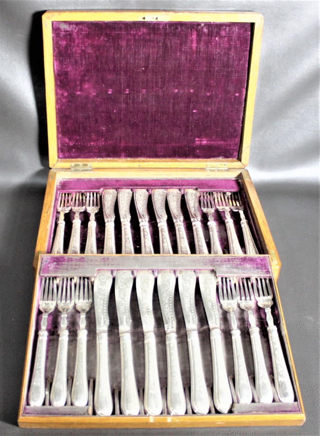 This antique boxed set of silver plated flatware is hallmarked, but the specific maker could not be identified. It is presumed this fish set was made in England in approximately 1920 in a late Victorian style. The set consists of twelve knives and