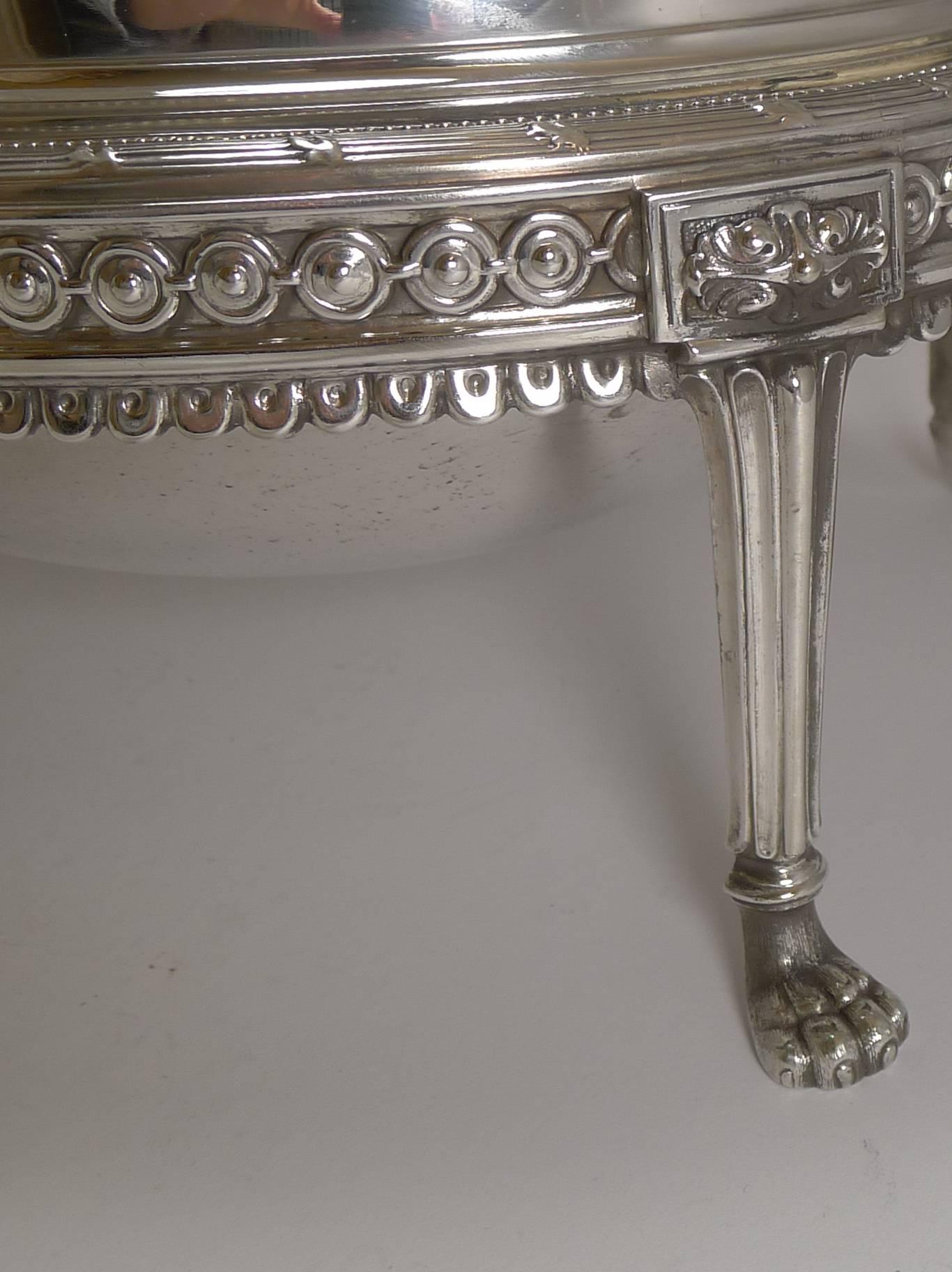 An absolutely fabulous and grand revolving silver plated breakfast dish standing on four Lion's paw feet, very English and very Victorian. There is a beautiful cast border running around the dish and the domed top is beautifully engraved with a