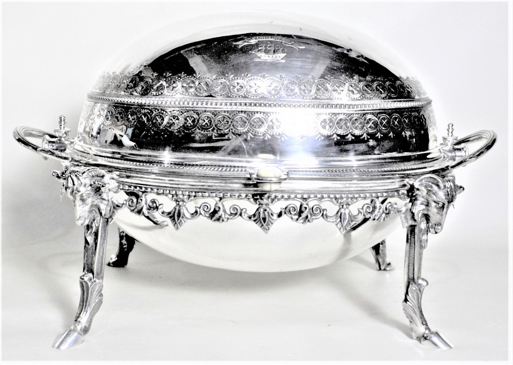 This antique silver plated revolving breakfast domed server was made in England in cicra 1890 in the period Victorian style. This server features four ornately cast figural rams heads on each corner with detailed hoofed ram's legs as legs for the