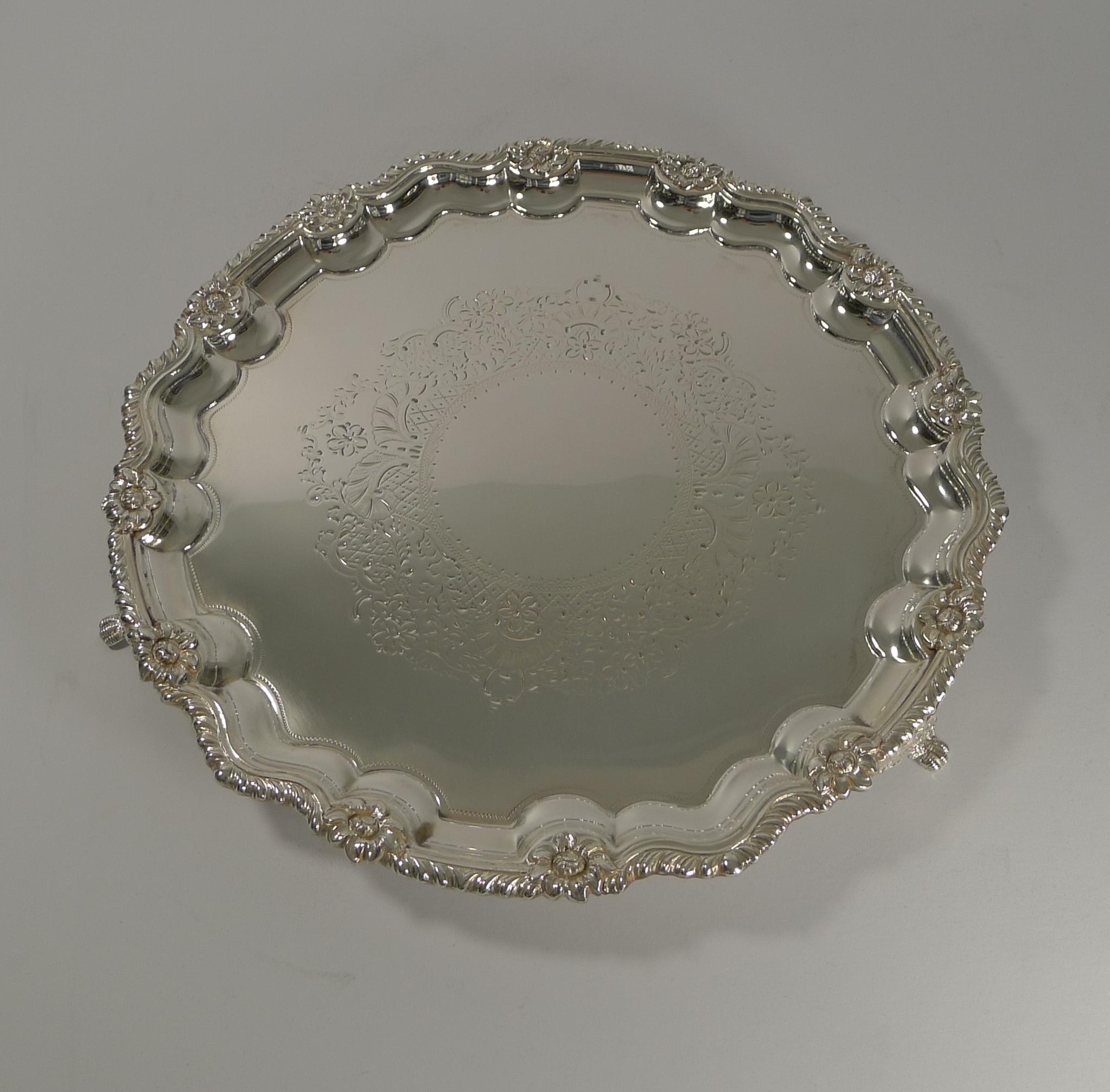 A very elegant late Victorian silver plated drinks salver or tray, perfect to serve cocktails or even hors d'oeuvres.

Standing on three lovely feet, the centre of the tray with an engraved decoration and the shaped edge with a wonderful raised