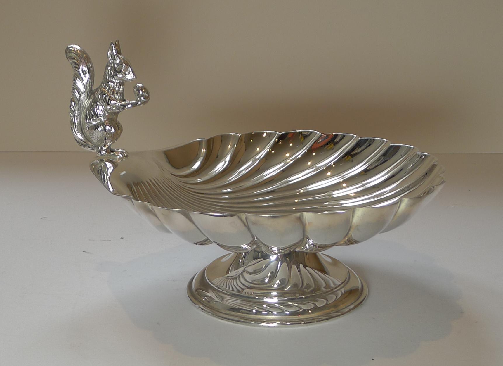 A fabulous and very smart nut dish (it looks great filled with fruit and nuts, even chocolates) featuring a cheeky squirrel munching away.

Just back from our silversmith's workshop where it has been professionally cleaned and polished, restoring