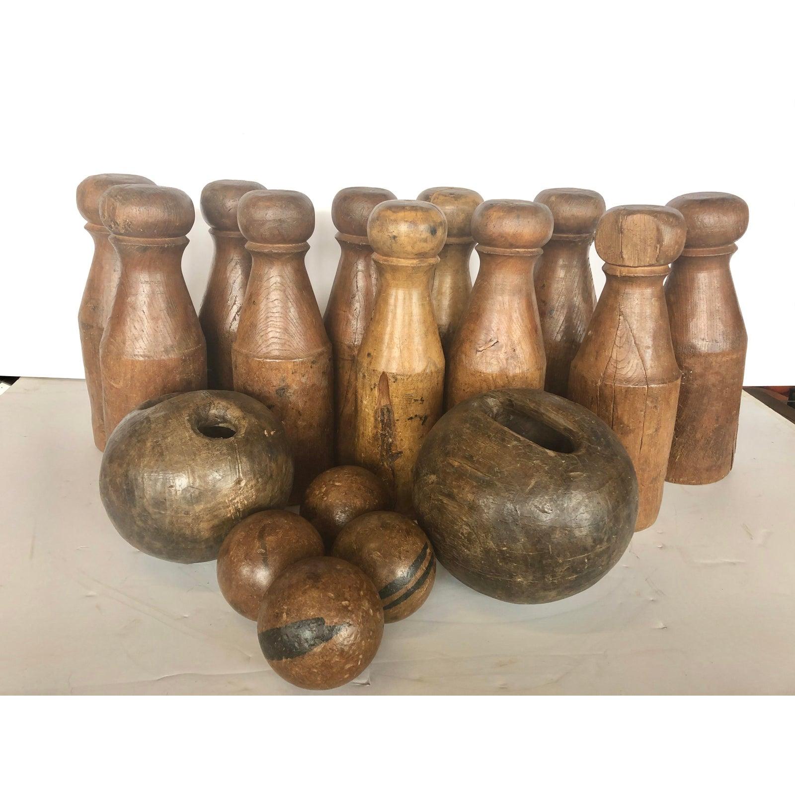 Large antique English skittles/lawn bowling game set. Set includes 11 pins 18.5” by 6”, 2 big balls 10” diameter and 4 small 5