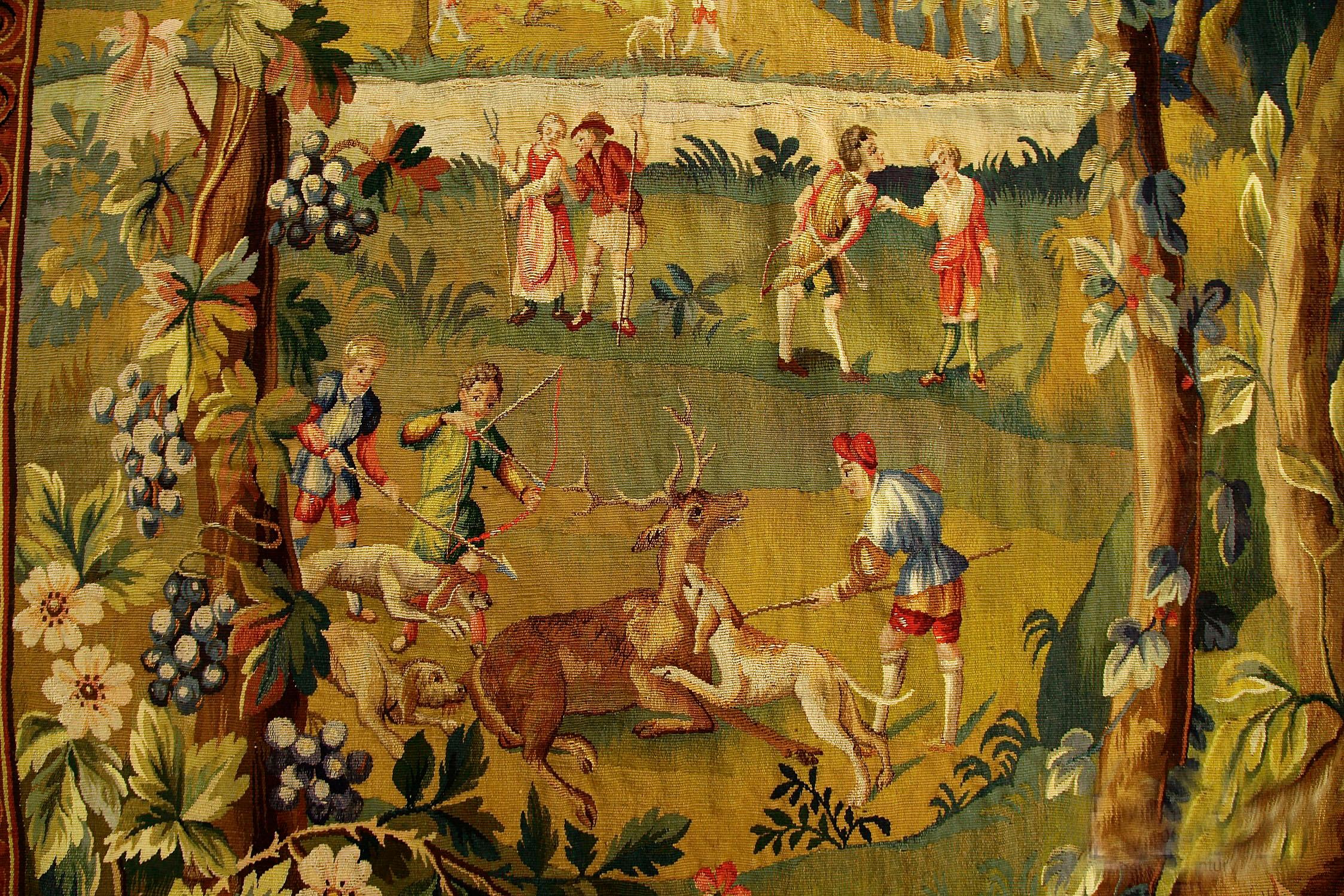 Antique English Soho Tapestry Circa 1900  6'7 x 6'7 depicting a hunting scene. The tapestry is filled with detailed depictions of hunters on horse back both men and women, colorful birds and trees with floral interspersed all in intricate detail.