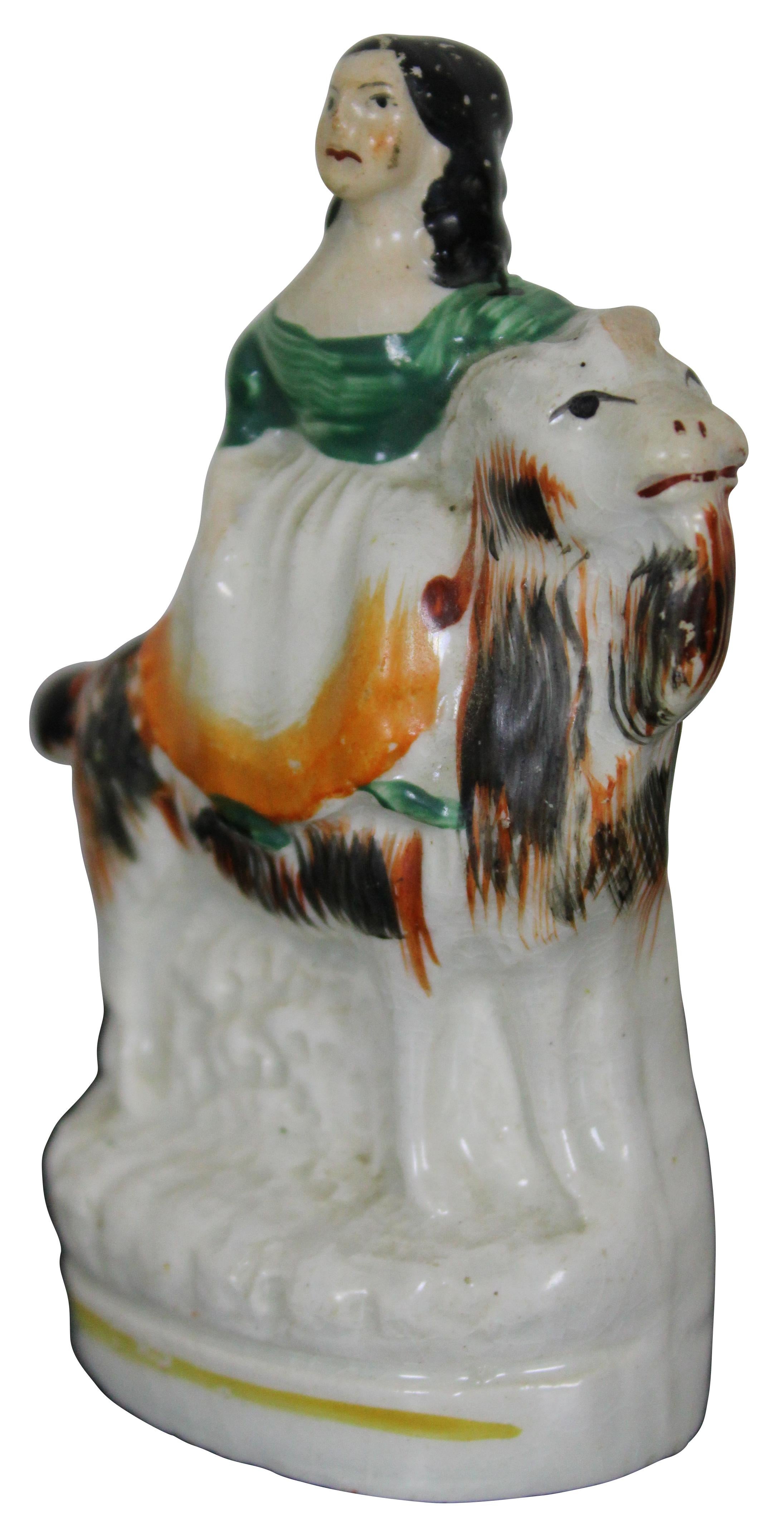 Antique Staffordshire porcelain figurine of a girl riding a goat. Measure: 4