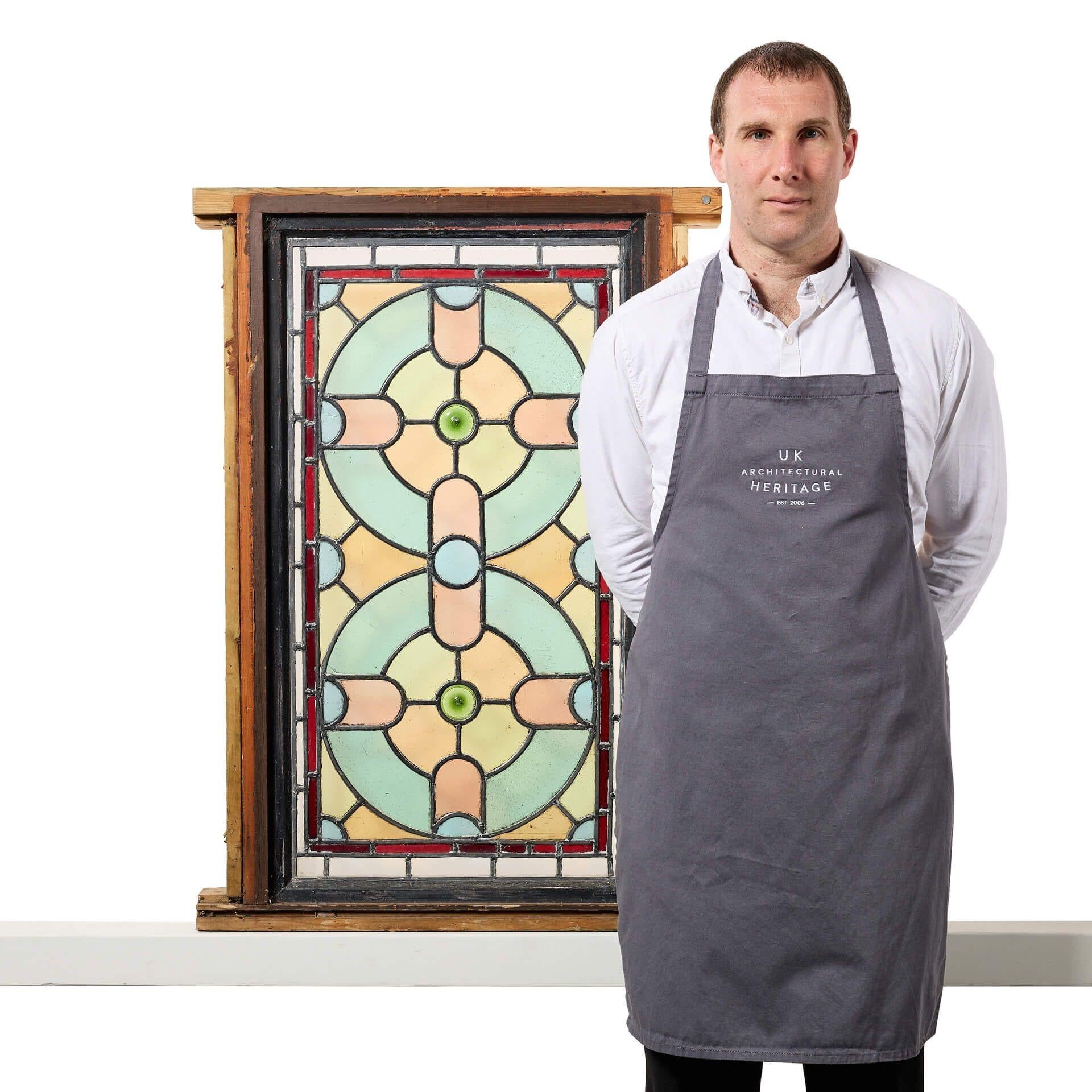 A late Victorian antique English stained glass window, circa 1900. We are also selling a second window in the same design.

This colourful stained glass window is tall in scale and currently fixed into a wooden frame. The panel is decorated with