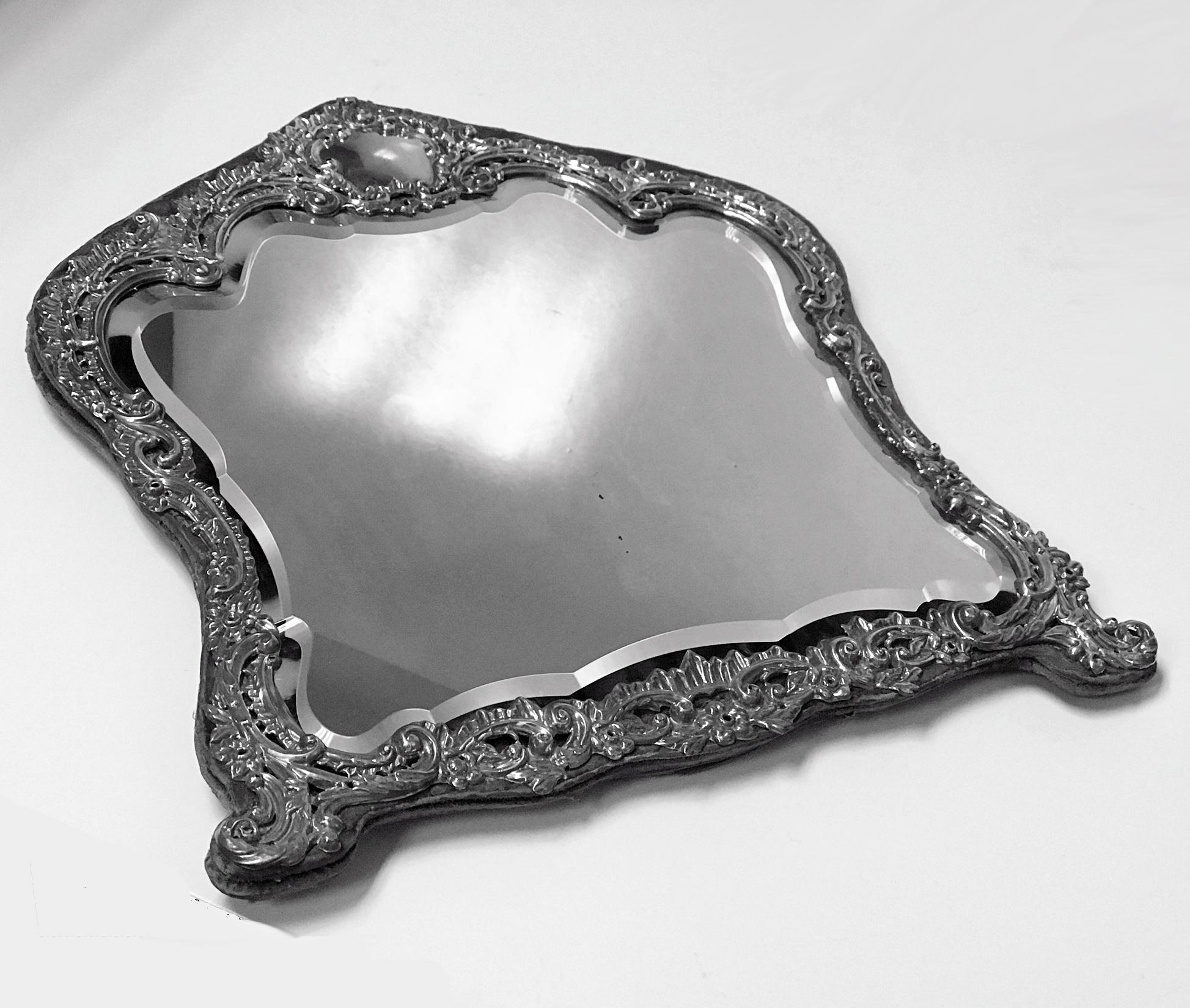 Antique Victorian sterling silver large table vanity mirror, Birmingham 1898 H. Matthews. The Mirror with floral decoration, top vacant cartouche, original bevelled mirror, and purple velvet backing with easel stand. Measures: Height 14 inches,