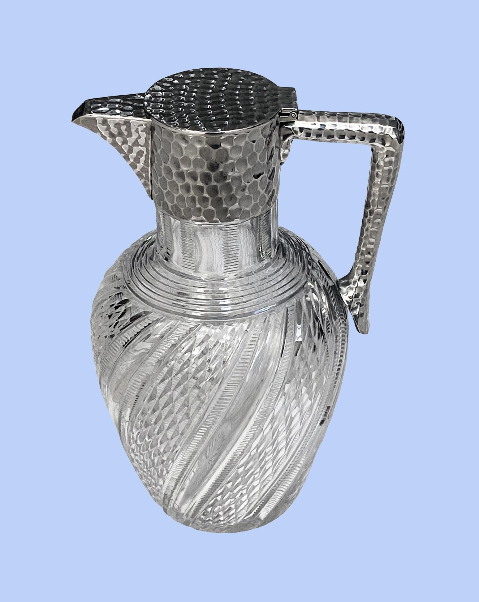 Antique English Sterling Silver and Glass Claret Jug John Grinsell & Sons, Birmingham 1896. The handle mount and cover all hammered sterling silver body with beautifully cut crystal and swirl glass design. Condition: Good. Glass clean, no staining.