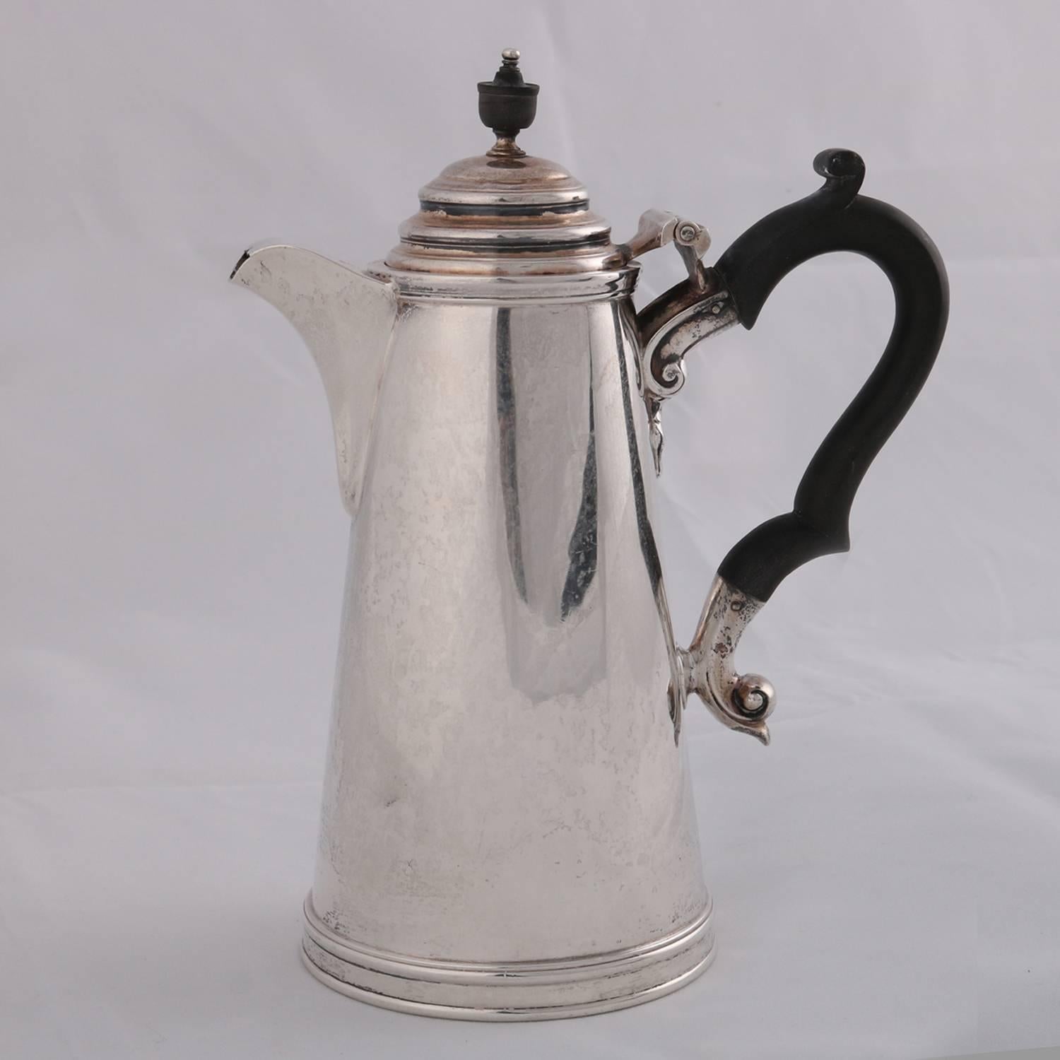 English sterling silver coffee pot by James Dixon & Sons features simple and plain tapered cylinder form on stepped collet foot with hinged dome lid having carved finial, flanked by elevated spout and carved scroll form wood handle, British touch