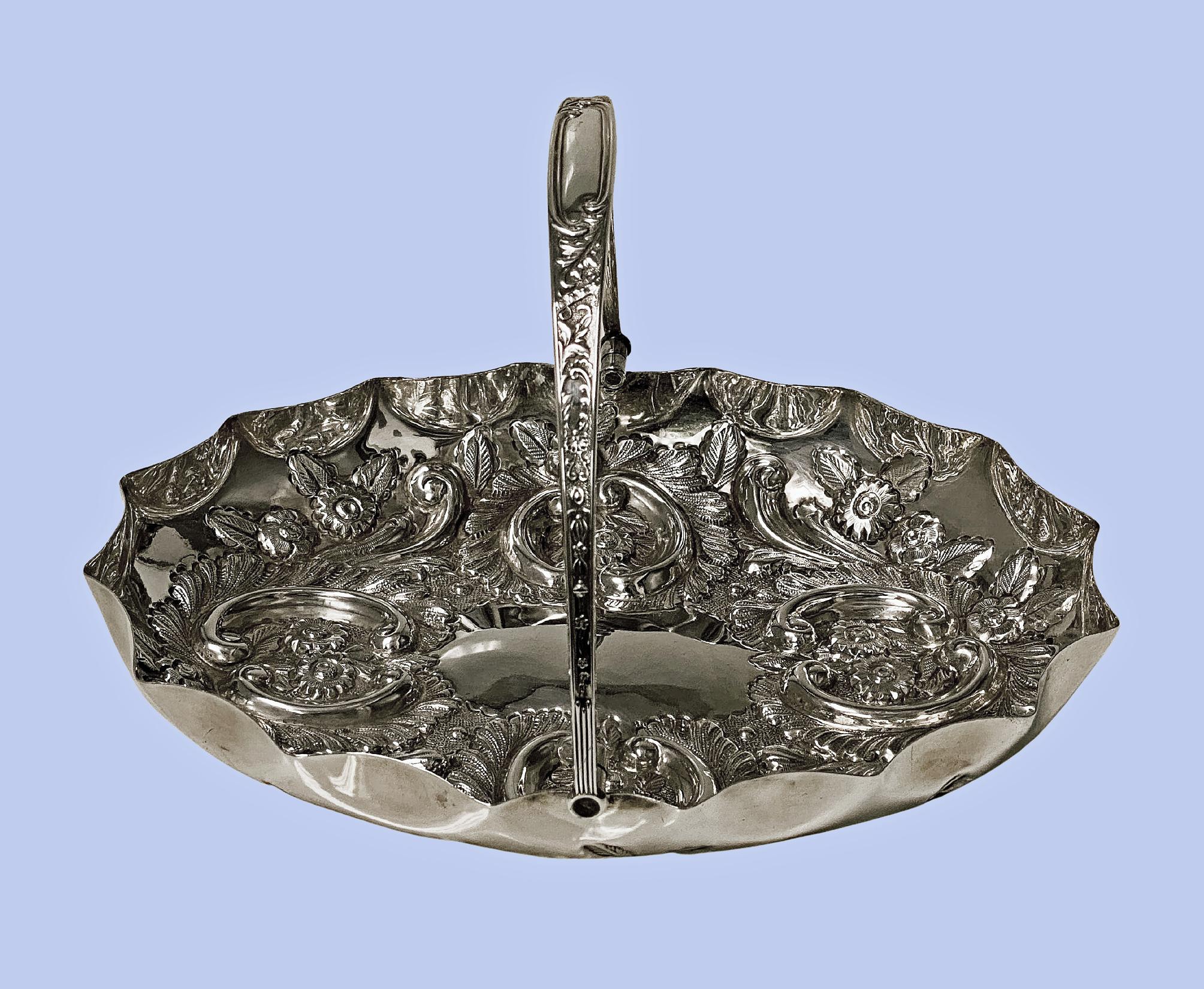 Antique English Sterling Silver Fruit dish basket, Birmingham 1902, Bennett Ltd. The oval basket with scalloped border the centre plain with a surround of very elaborately embossed repoussé fruits and foliage decoration. Measures: 10.00 x 7.50 x