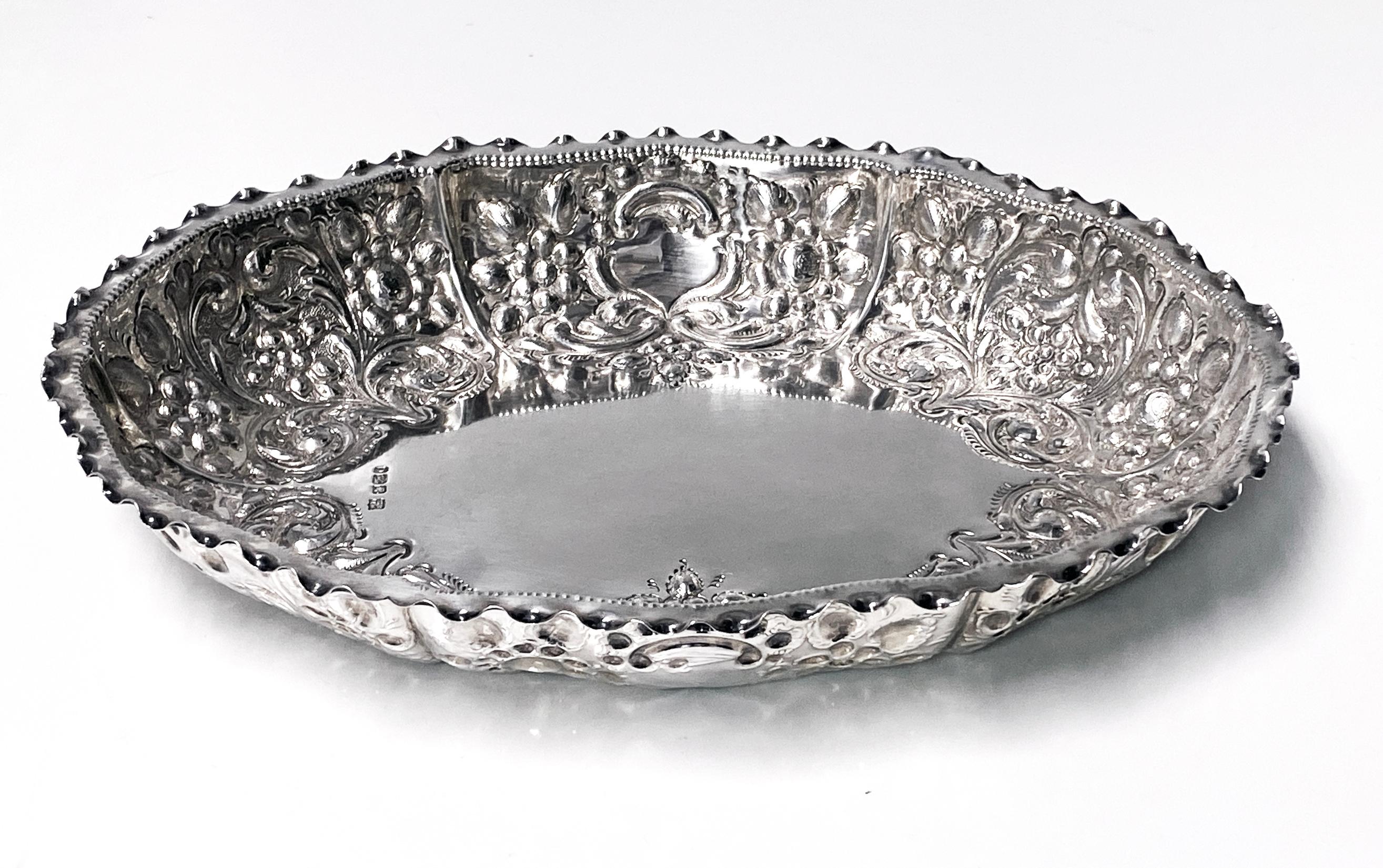 Antique English Sterling Silver Fruit Dish 1895 William Padley. The oval shape Dish with richly decorated chased embossed and engraved foliage fruit decoration and plain centre, crimped scalloped border. Full hallmarks for Sterling Silver from city