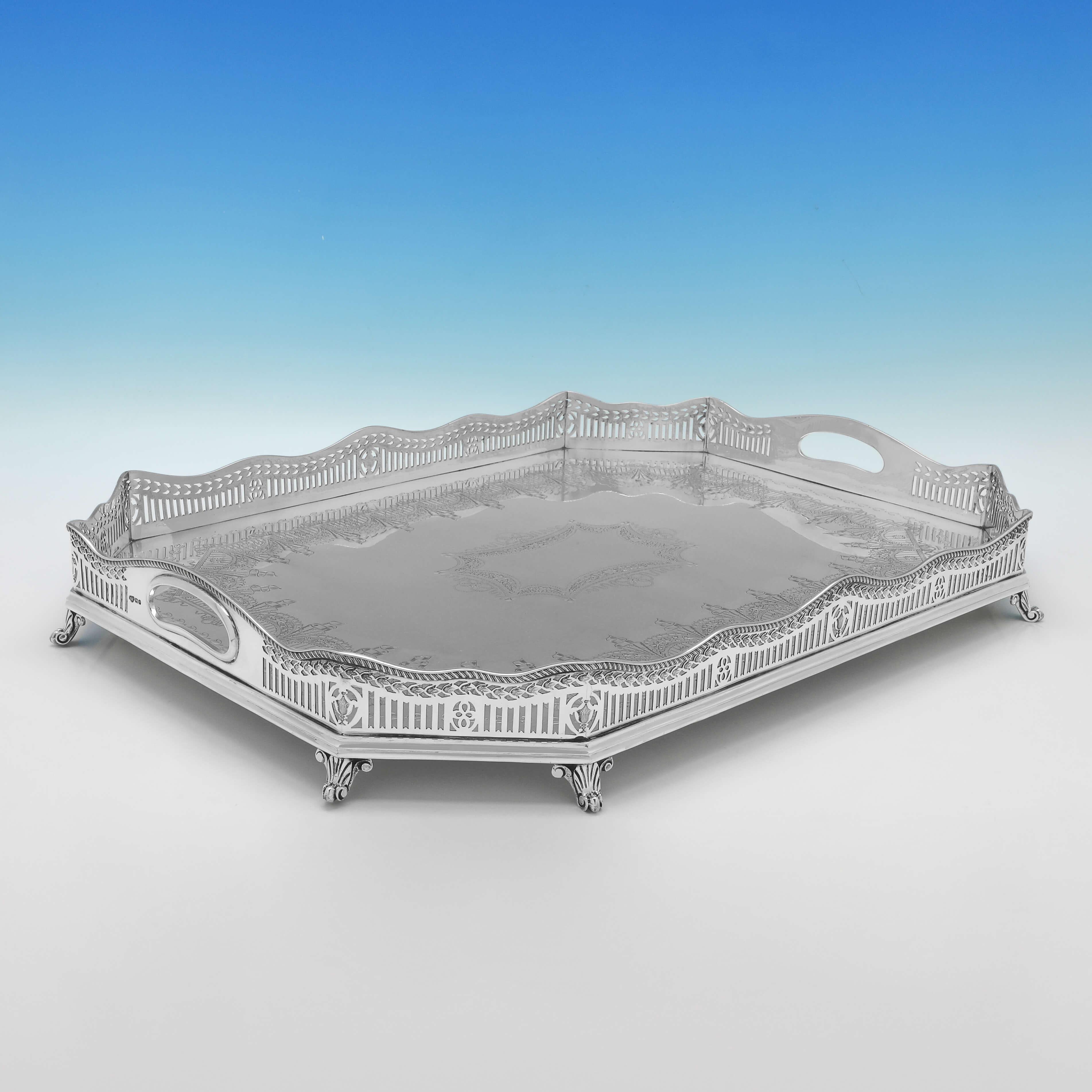 Poinçonné à Sheffield en 1917 par Goldsmiths & Silversmiths Co, ce très joli plateau ancien en argent sterling est de style galerie, avec une bordure percée, une magnifique décoration gravée au centre, et repose sur 8 pieds. 

Le plateau mesure 8,5