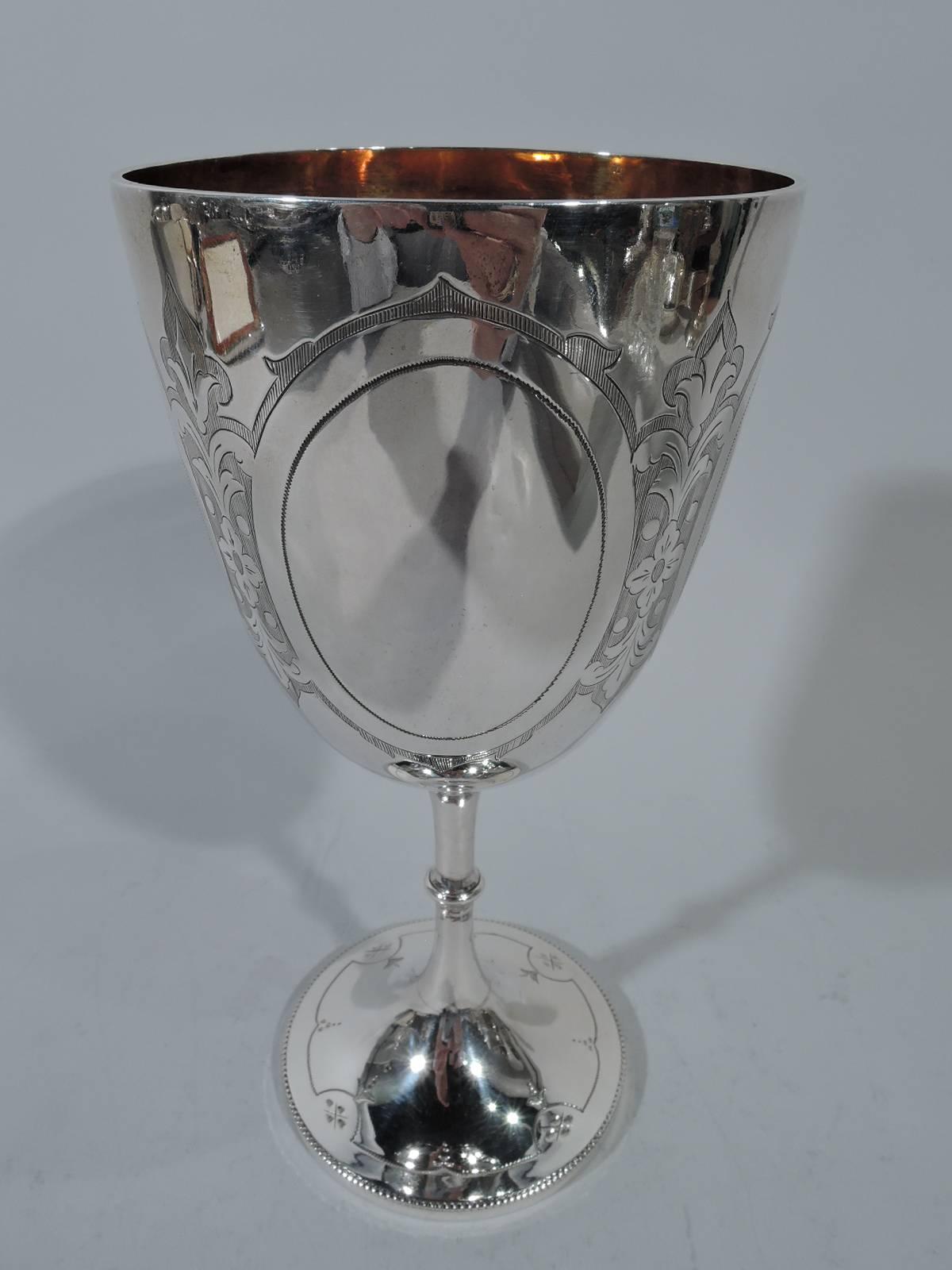 Victorian sterling silver goblet. Made by John & Henry Lias in London in 1875. Tapering bowl on knopped stamp on raised foot. Stylized ornament on shaded ground. Four oval frames joined by flowers. Two frames inset with bouquets; other two vacant.