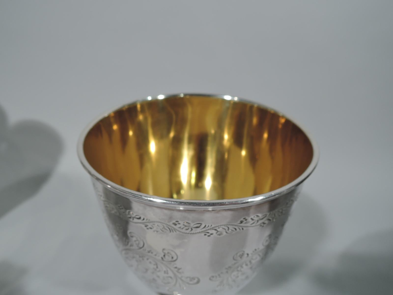 Victorian sterling silver goblet. Made by Atkin Brothers in Sheffield, England in 1877. Bowl has curved and tapering sides. Cylindrical stem terminates in raised foot. Exterior engraved with fluid leaf volute scrolls of which two form heart frames.