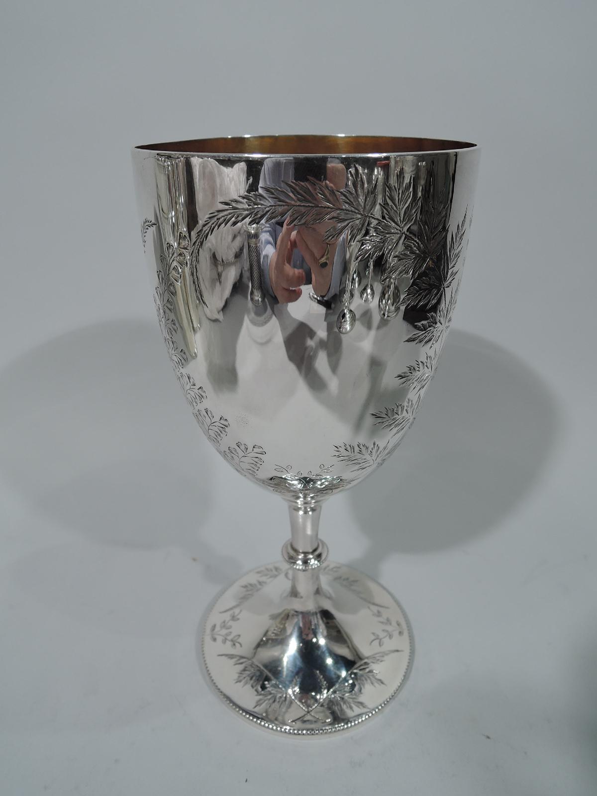 Victorian sterling silver goblet with engraved foliage. Made by Henry Holland in London in 1877. Curved and tapering bowl on cylindrical stem with beaded knop and raised foot. Bowl exteriro has engraved foliage including sweeping branches forming