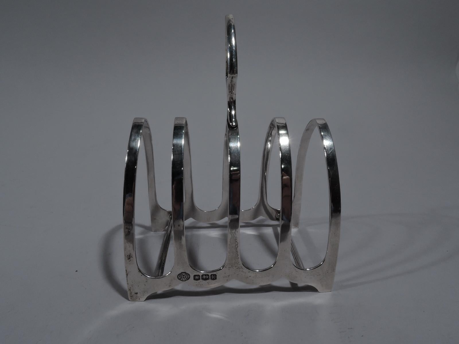 George V-sterling silver toast rack. Made by William Hutton & Sons in Sheffield, England in 1927. Five Gothic arches with scalloped bottom rim and 2 stretchers. Central arch surmounted by trefoil handle. Fully marked. Weight: 2 troy ounces.