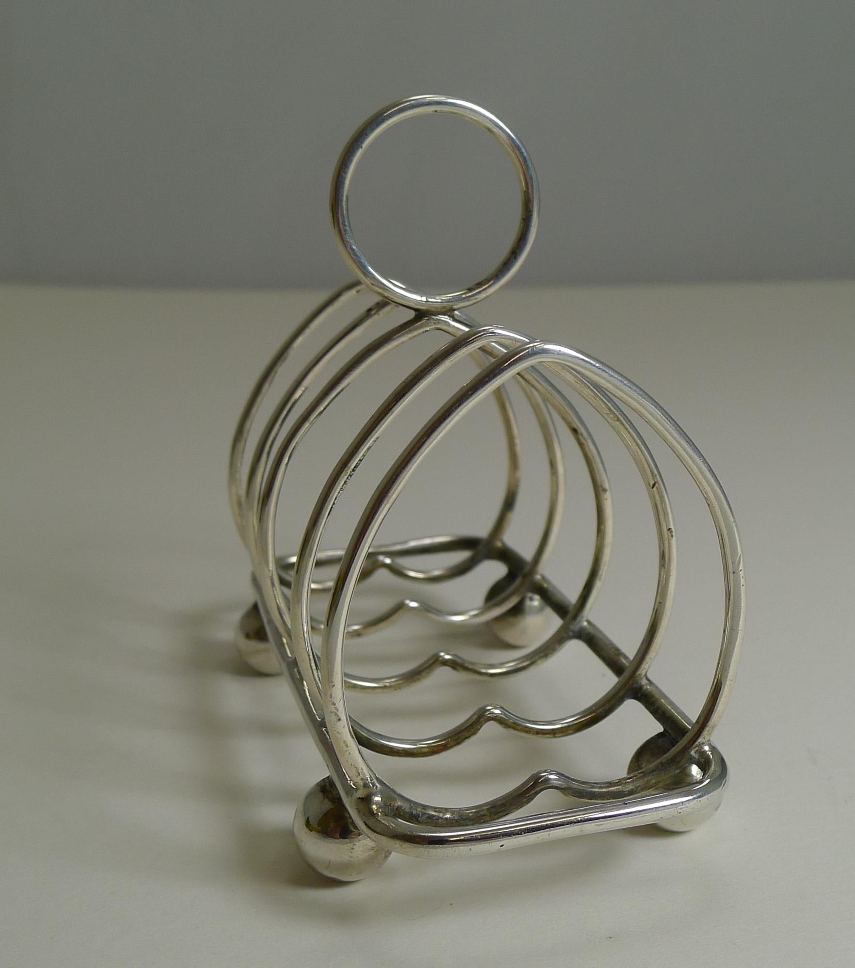 Pretty as a picture, this romantic little toast rack would look equally at place on a desk-top used for small letters or business cards.

The silver is fully hallmarked for Sheffield 1912, a true antique example over 100 years old. The makers mark