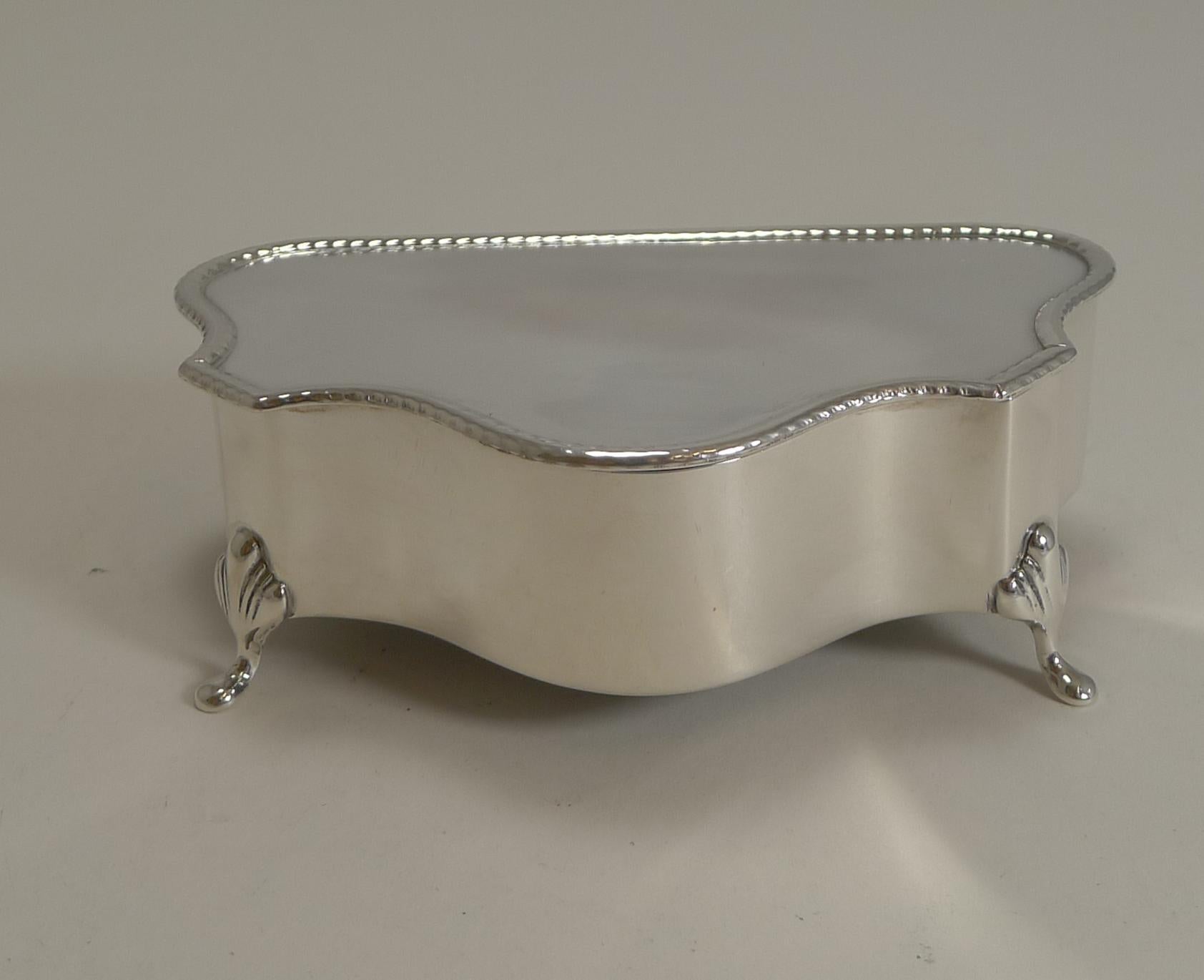 A beautiful and heavy sterling silver box beautifully shaped and standing on four very elegant feet.

A simple design with the border of the lid decorated with a rope design.

The hinged lid opens to reveal a black velvet lined interior, fresh