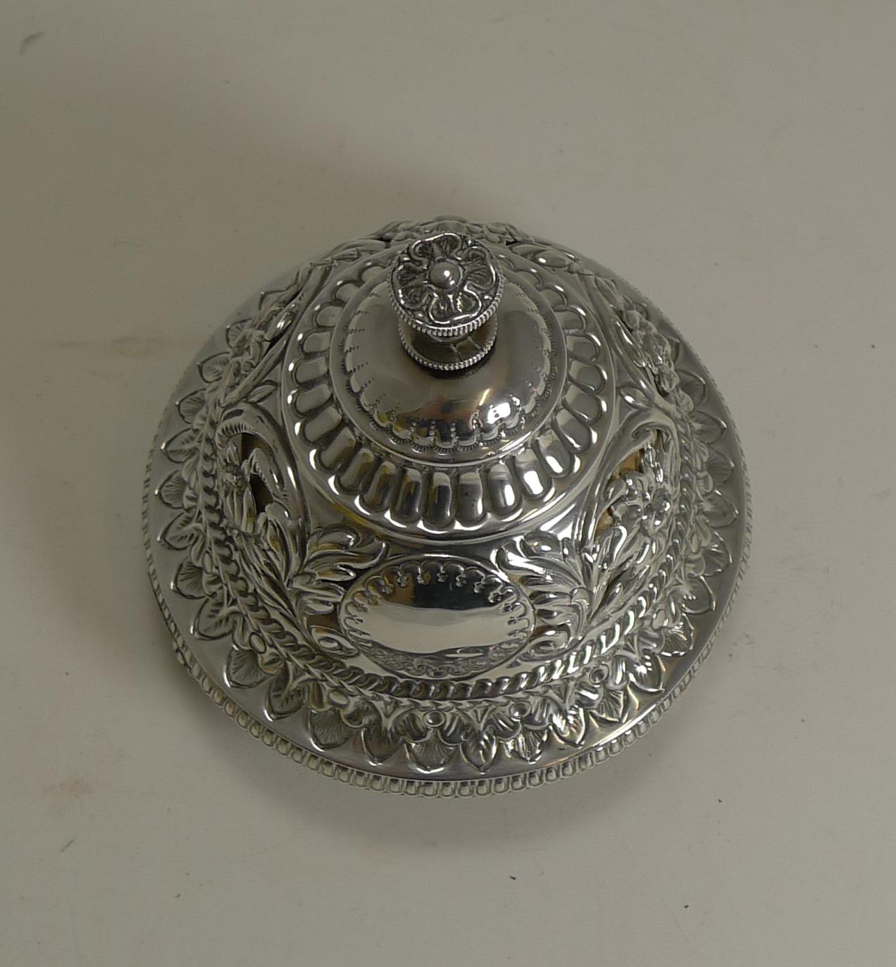 A magnificent Victorian mechanical table bell beautifully pierced or reticulated with floral and foliate decoration with a vacant circular cartouche to the front.

The finial to the top just needs a twist to create a clear, pleasant but