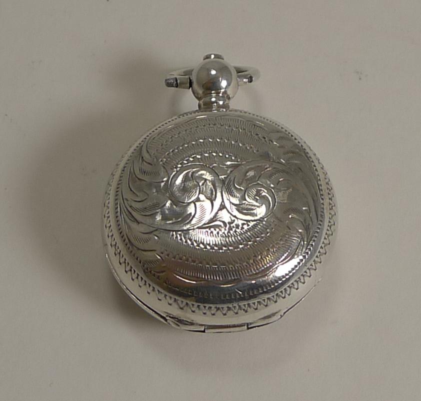 A wonderful antique English solid silver sovereign case, beautifully decorated both back and front; the front with a vacant shield-shaped cartouche.

The little button below the ring is pressed to release the lid. The interior is where the full