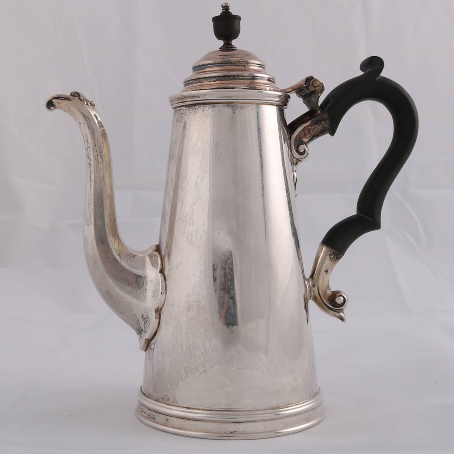 English sterling silver tea pot by James Dixon & Sons features simple and plain tapered cylinder form on stepped collet foot with hinged dome lid having carved finial, flanked by paneled swan neck spout and carved scroll form wood handle, British