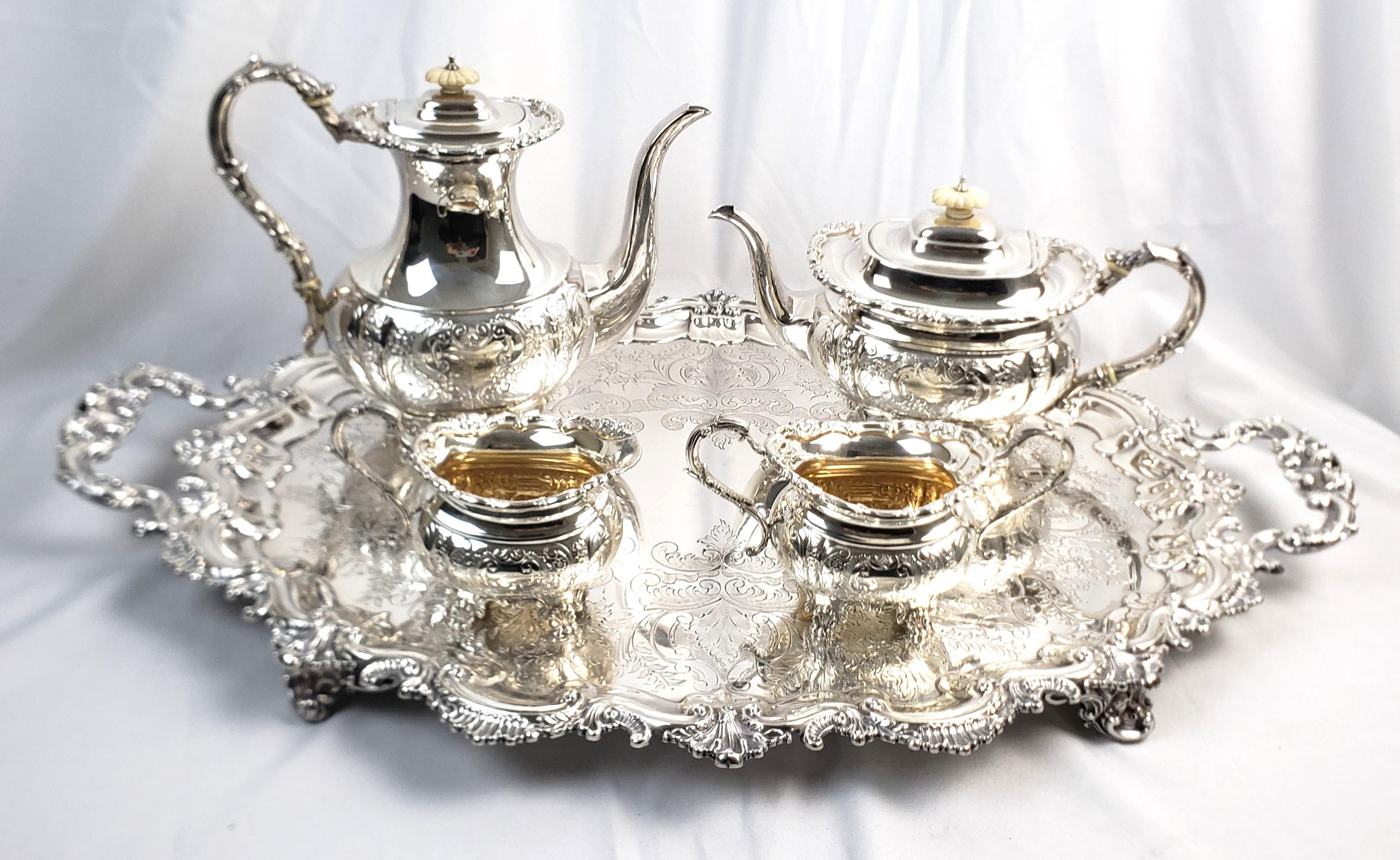 This antique tea set was made by and unknown maker, but the set and the tray originate from England and date to approximately 1850 and done in the period Victorian style. The four piece tea set is done in sterling silver and the handles and bases
