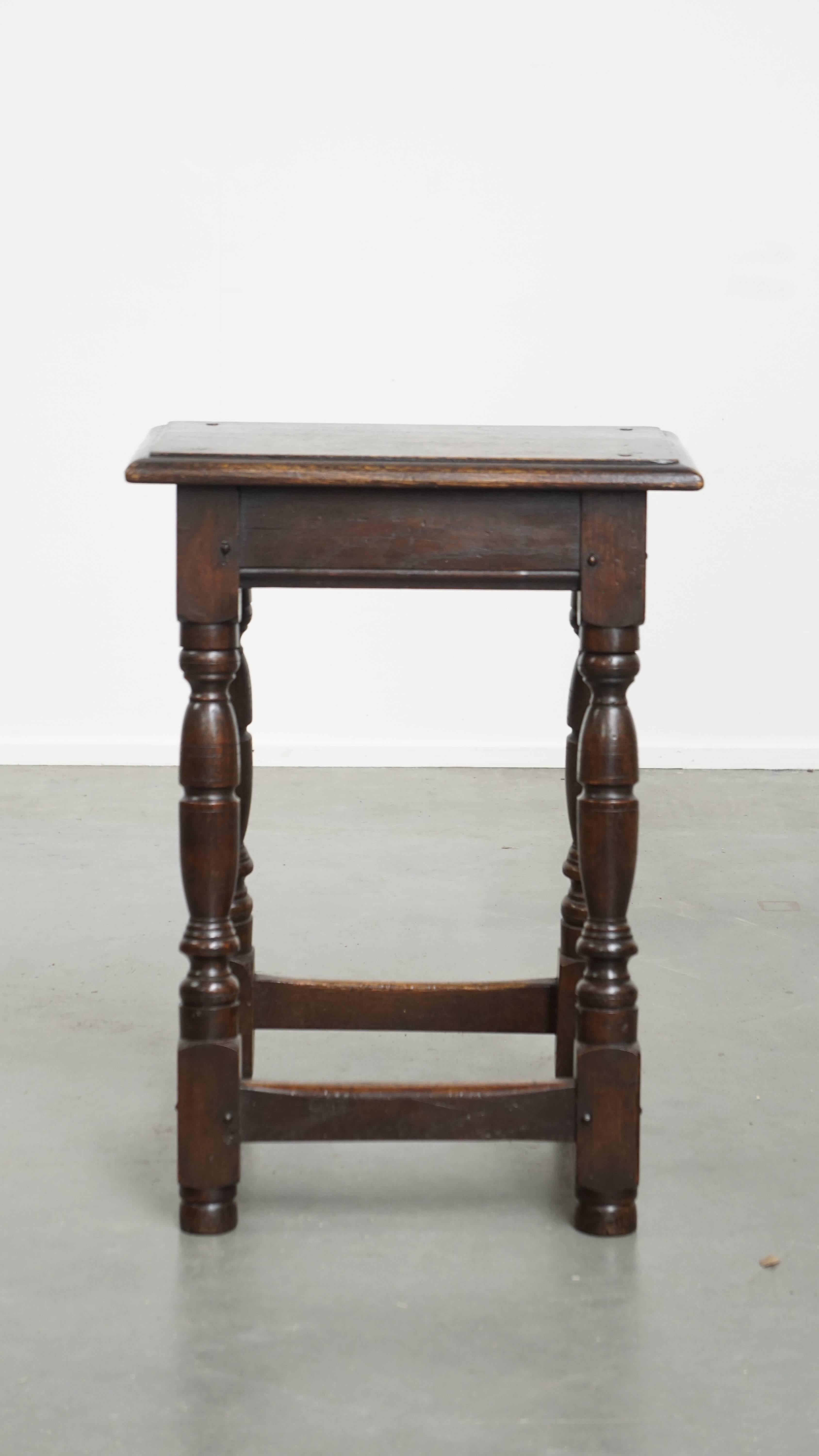 This charming and timeless antique English stool / joint stool / side table from the 18th century with elegant legs. This classic 18th-century English piece combines charm and functionality. Thanks to its sturdy construction, it can serve not only